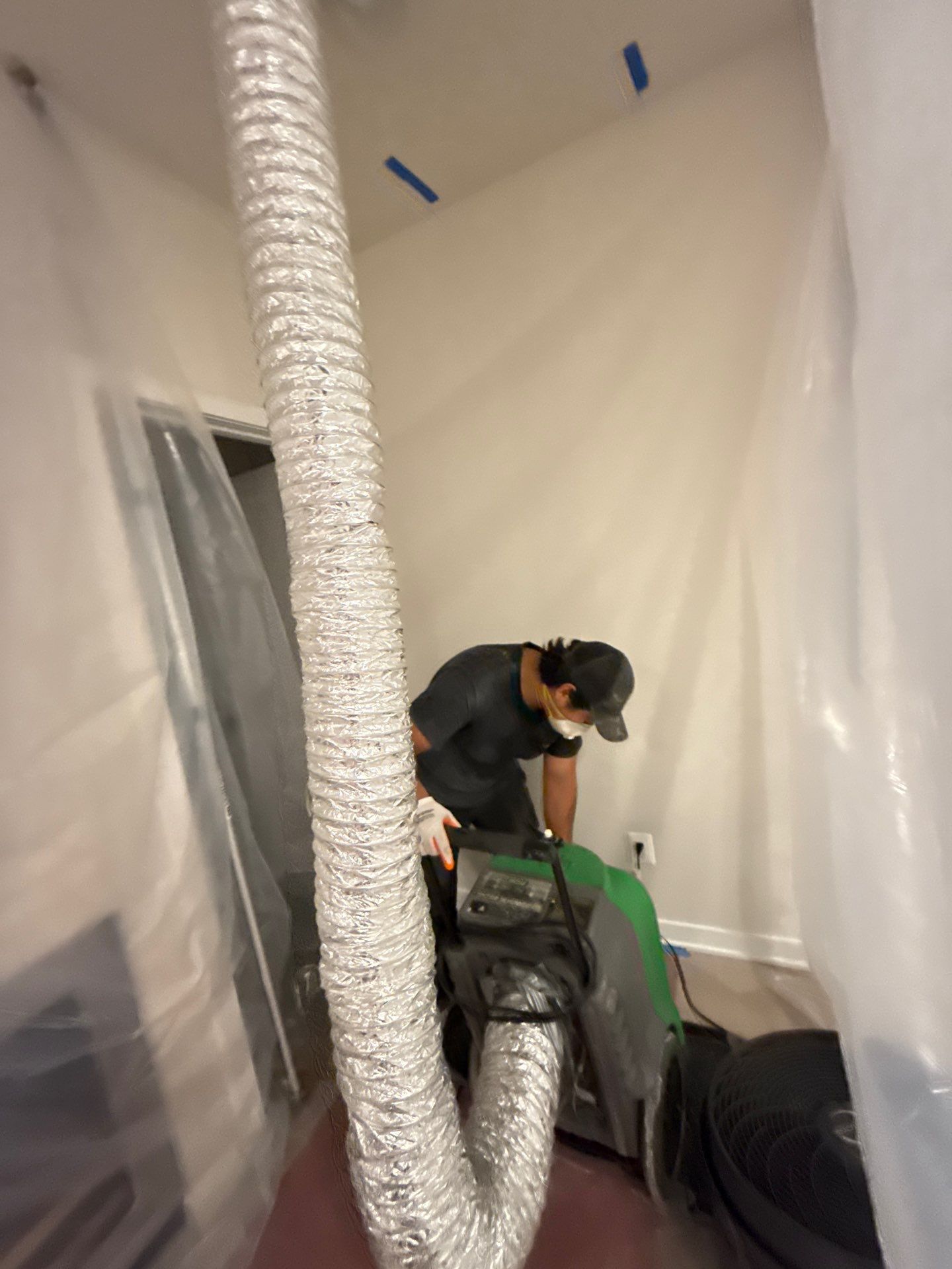 Dehumidifier positioned within containment zone to manage humidity levels during water restoration work.