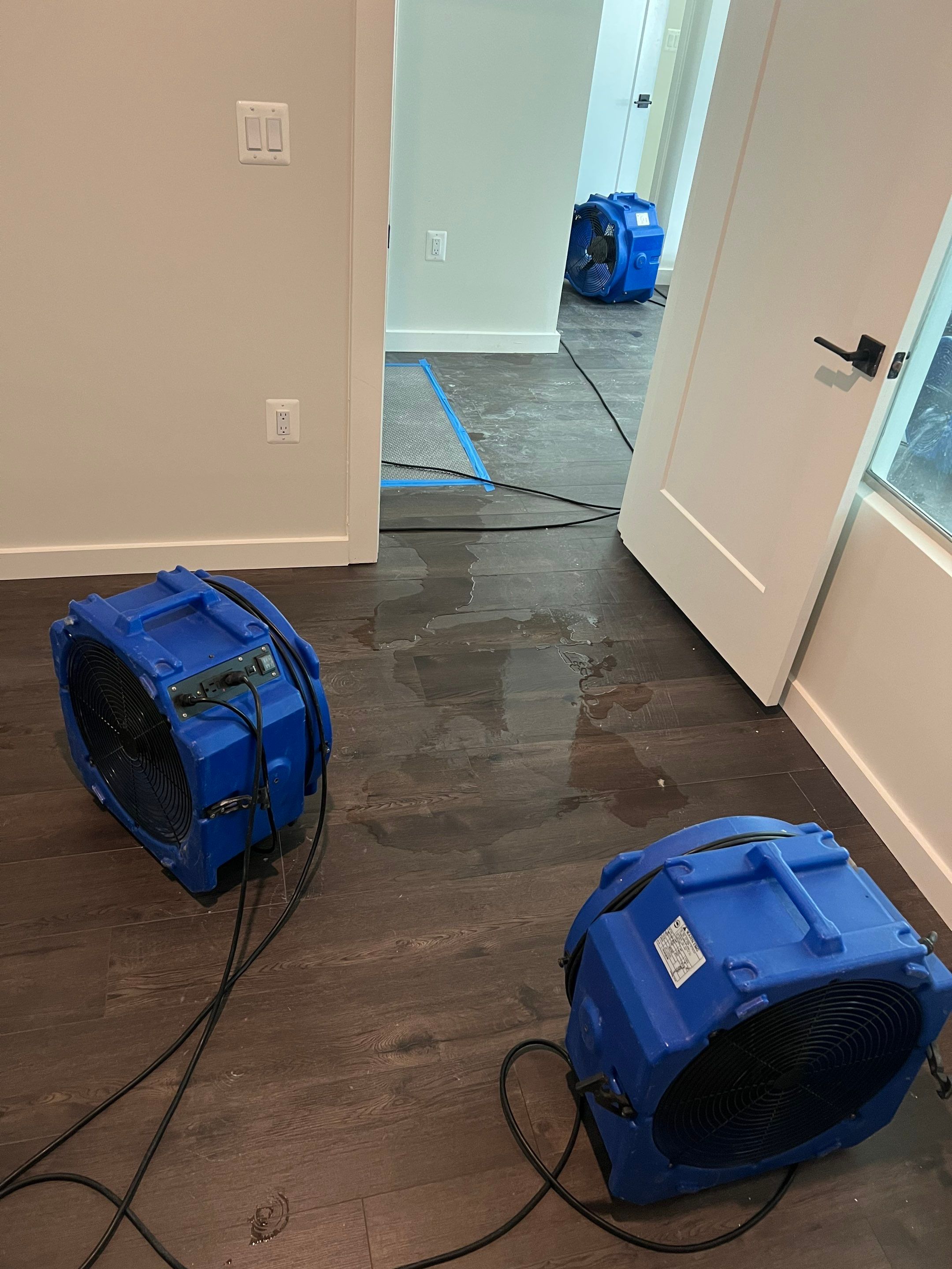 Water-damaged carpet and flooring in Arlington home with dehumidification equipment positioned for structural drying.