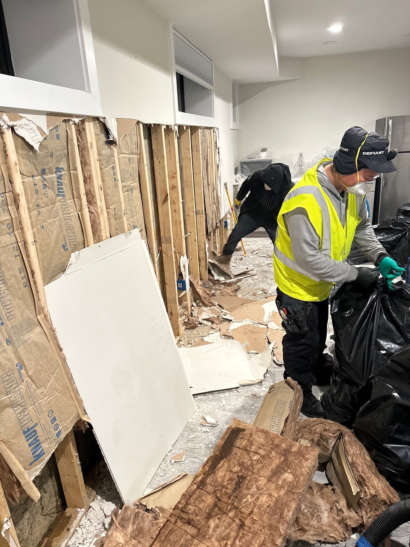 Mid-stage water restoration showing active dehumidification and barrier containment system.