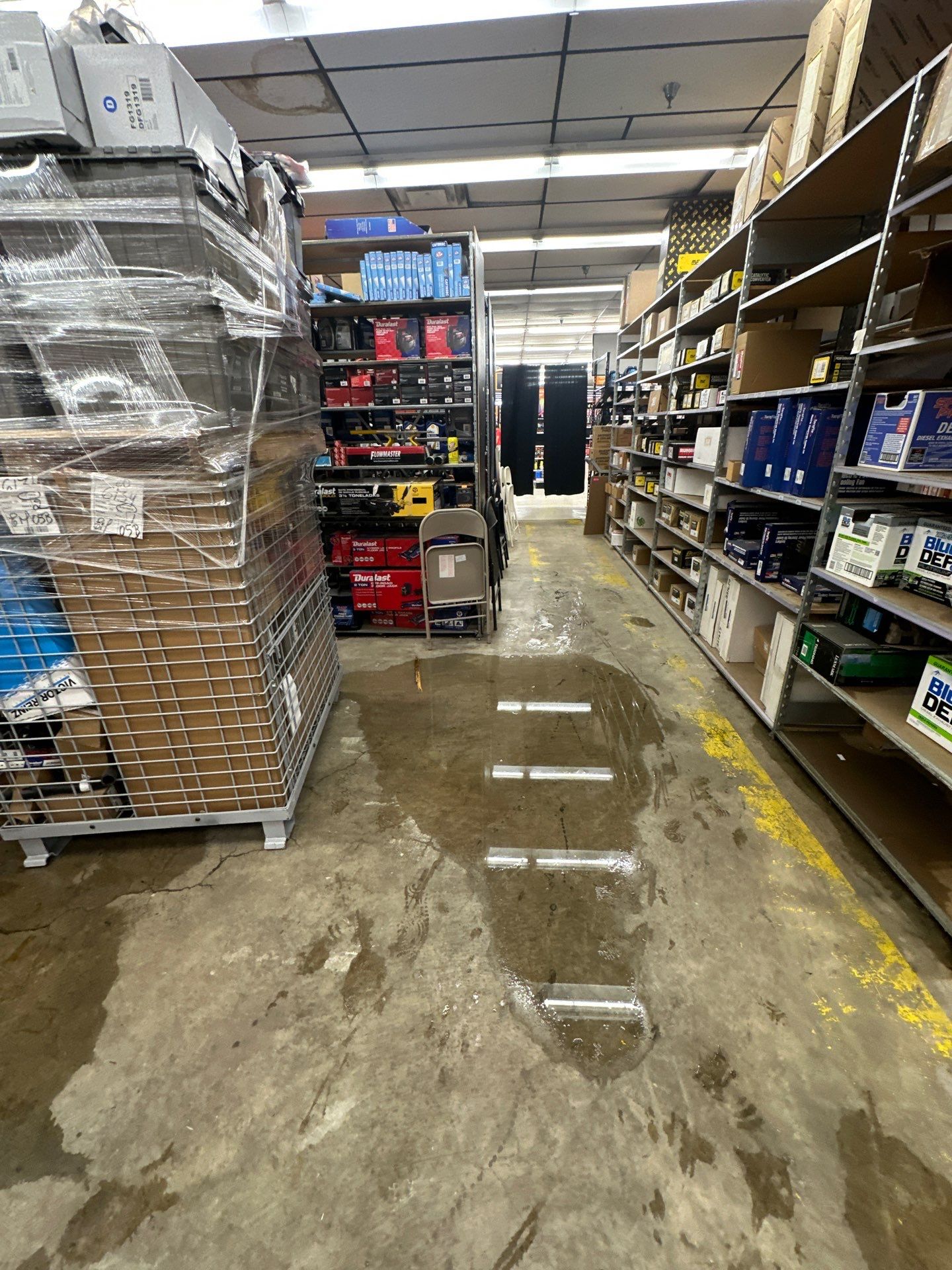 Standing water removal underway in Baileys Crossroads water damage restoration, extraction equipment deployed across wet flooring.
