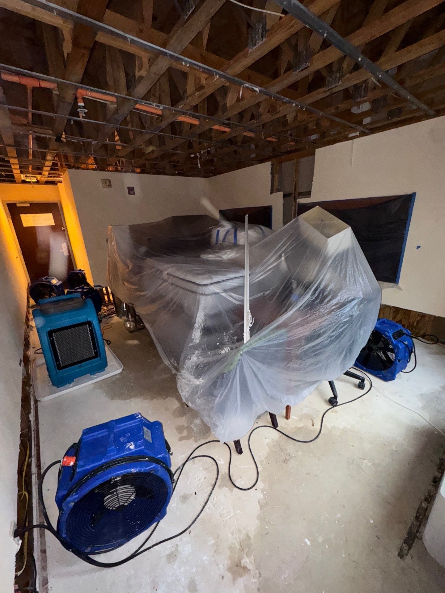 Wet drywall and framing exposed during water extraction and assessment in Manassas restoration work.