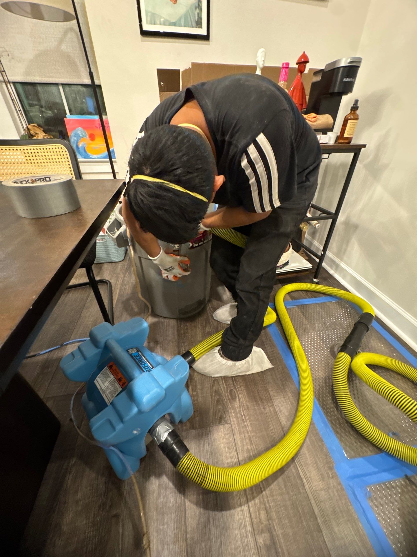 Dehumidification equipment positioned to extract moisture from affected structural cavities during active remediation.