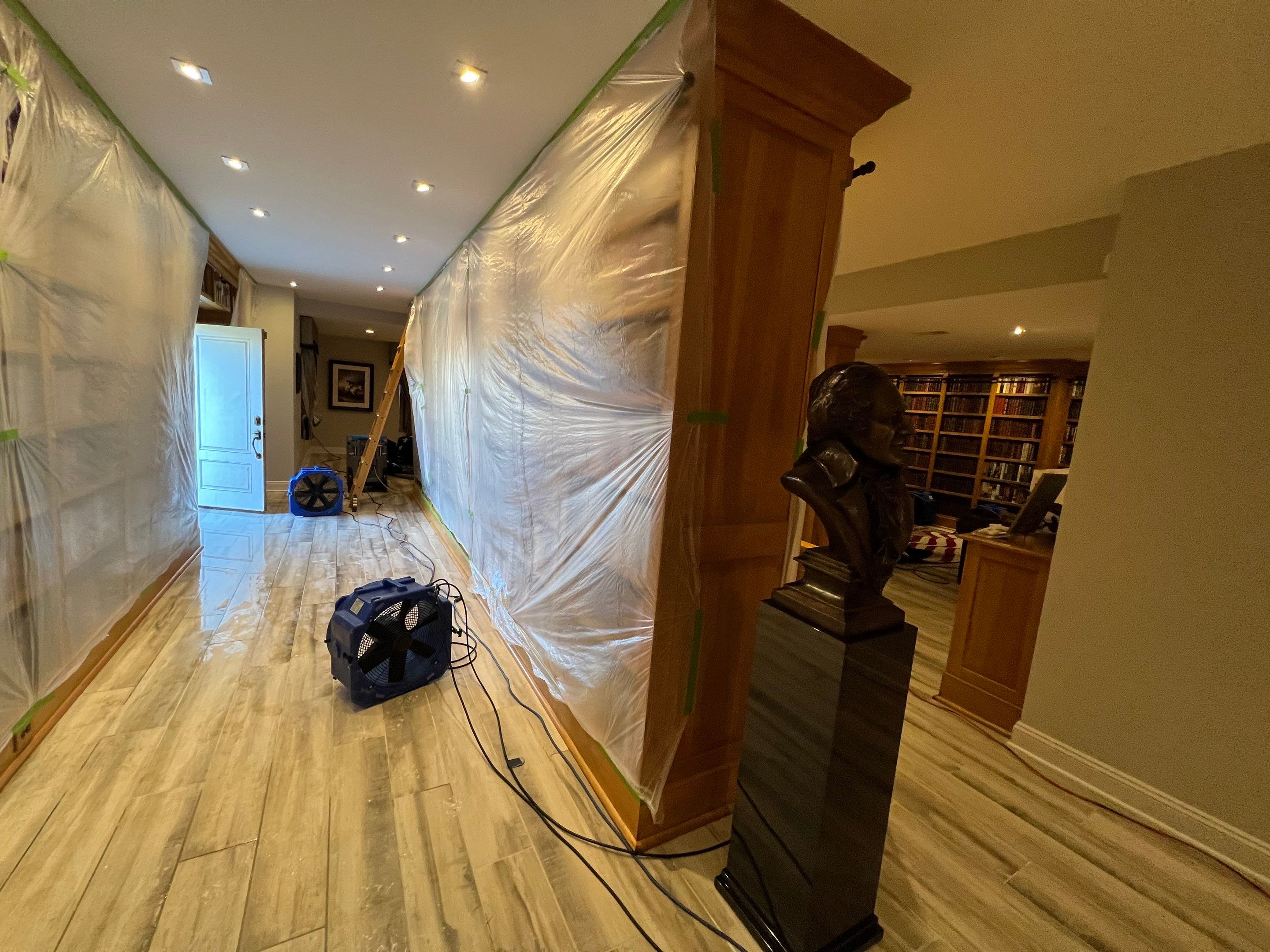 Final-stage water damage restoration with containment barrier and drying equipment in place.
