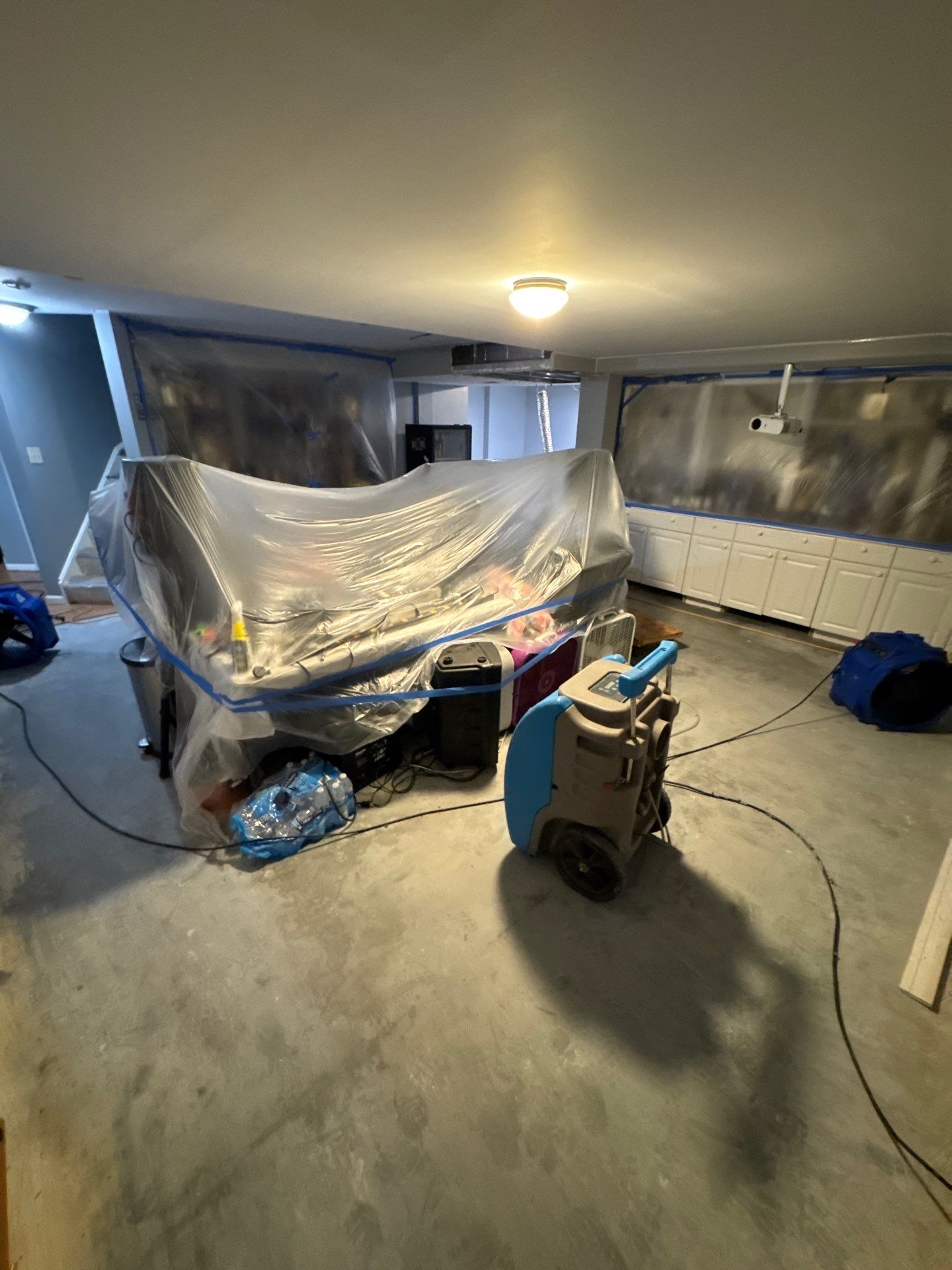 Structural drying equipment positioned to remove residual moisture from framing and substrates.