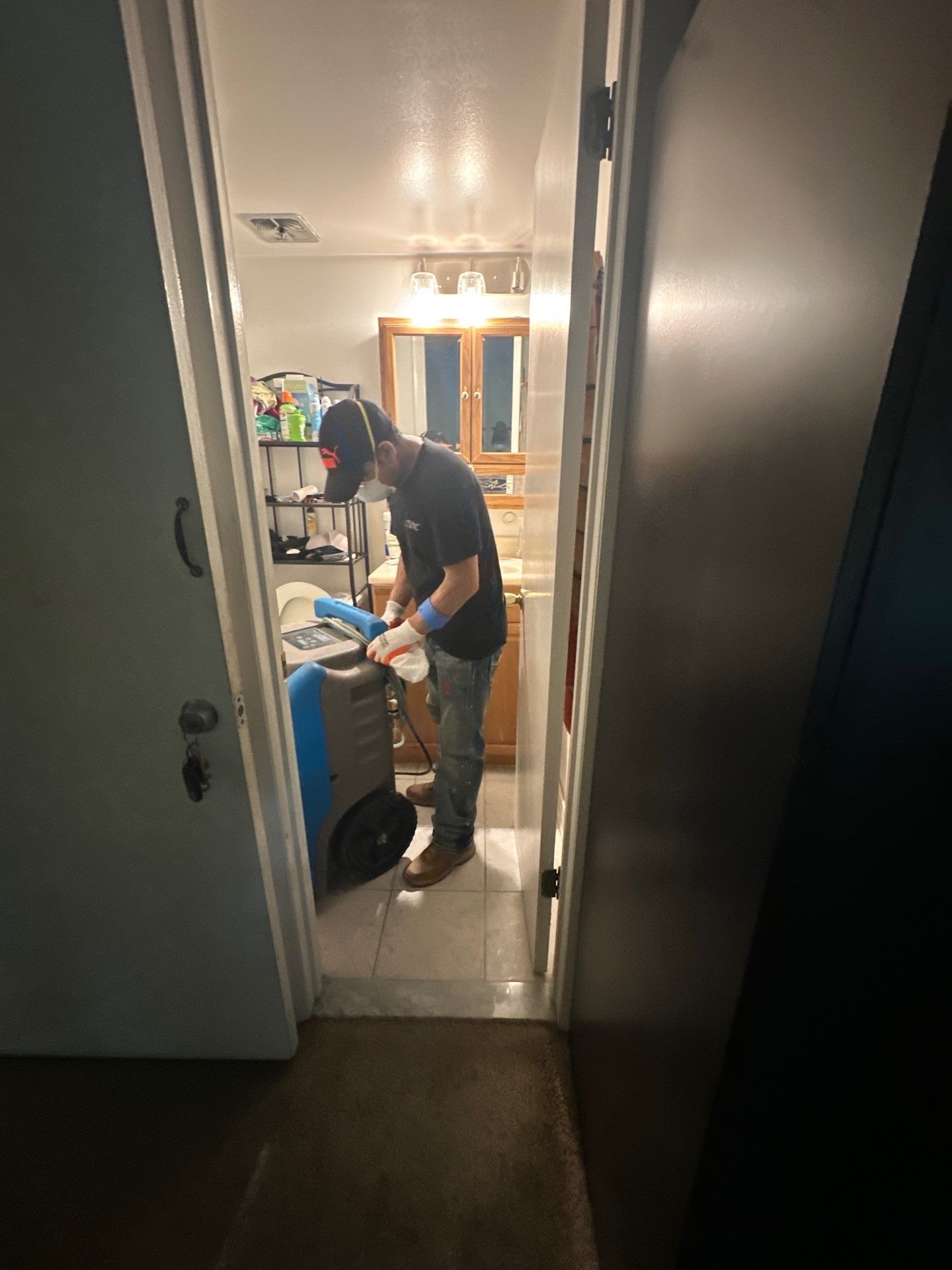 Dehumidifiers and air movers positioned for structural drying during water damage restoration.