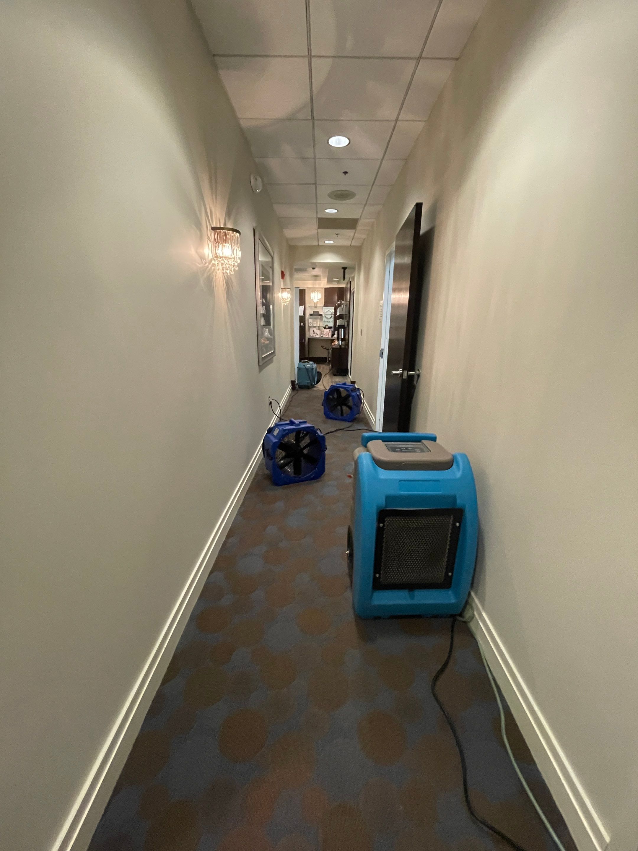 Mid-stage drying process with extraction and dehumidifier units operating in water-damaged space.