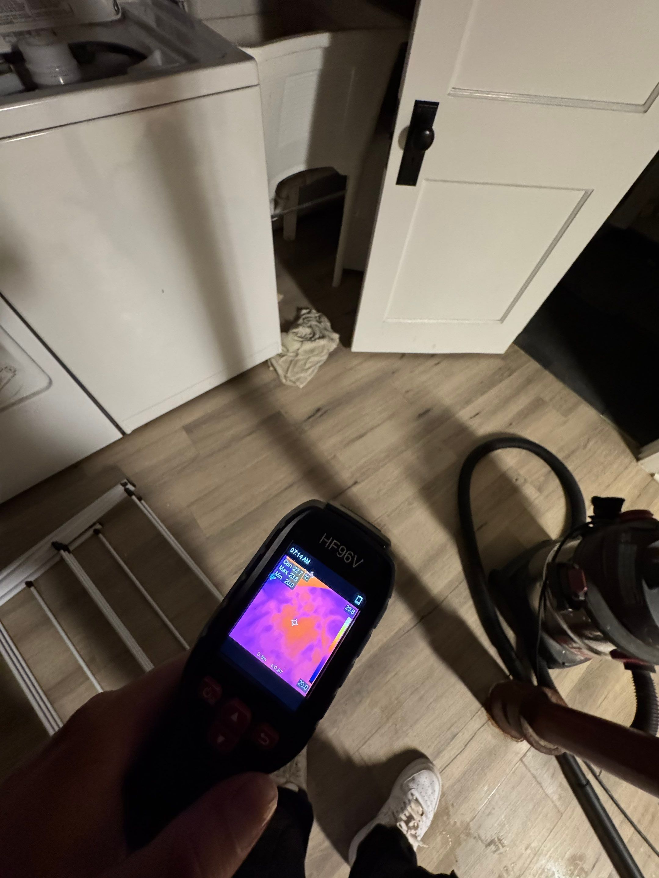 Thermal imaging camera detecting moisture in wall cavity during Arlington water damage assessment.