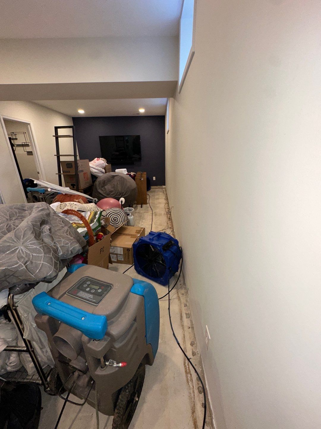 Structural drying in progress with dehumidifiers and air movers within containment.