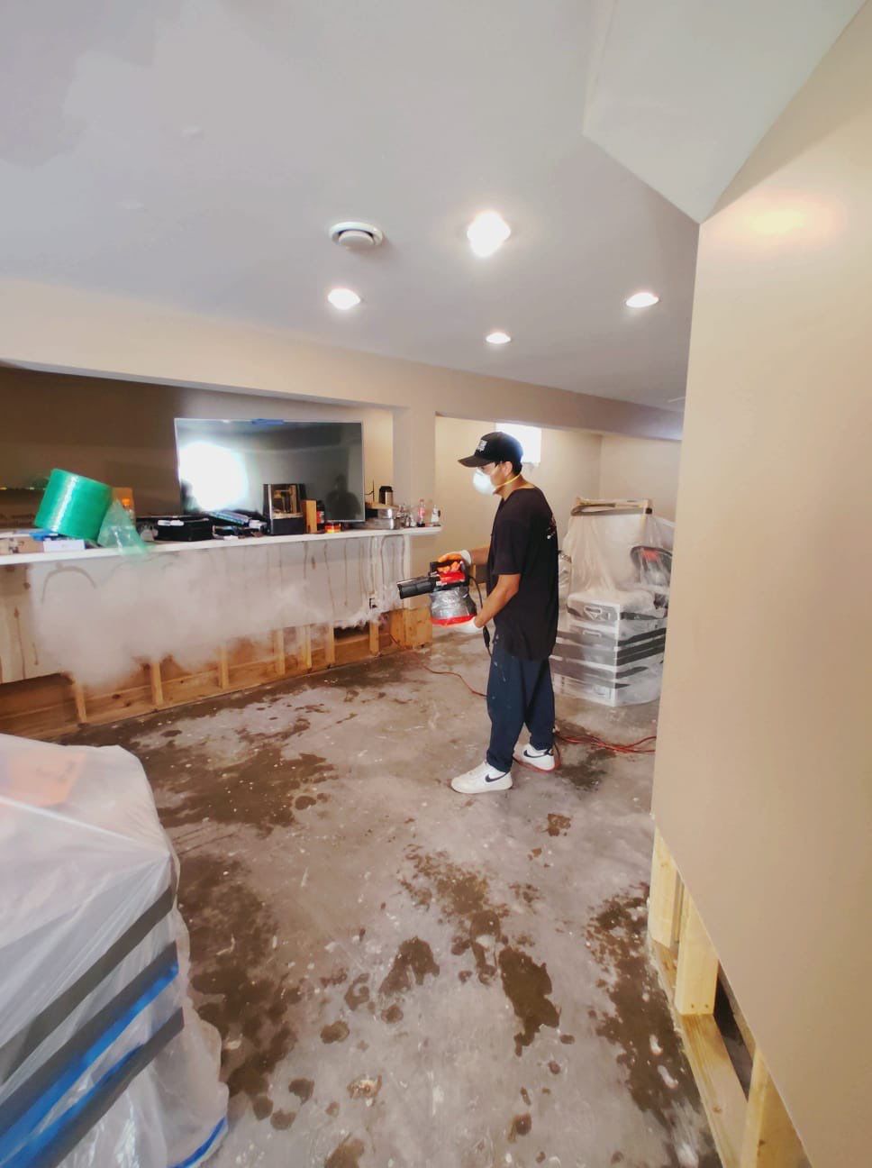 Containment and sanitizing work underway during water damage restoration sequence.