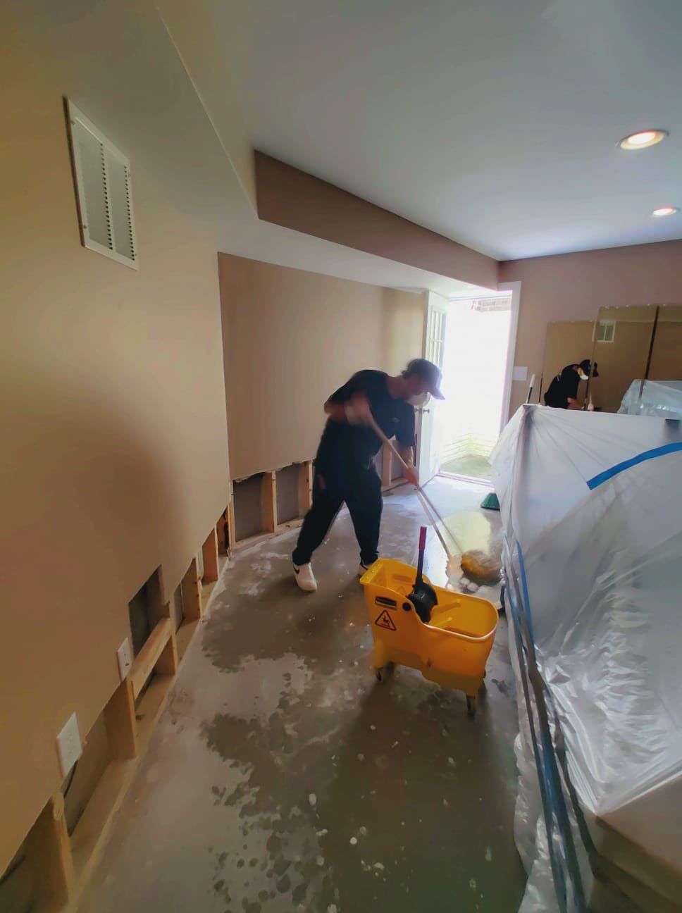Mid-stage drying process showing dehumidifier and air movement setup for moisture removal.