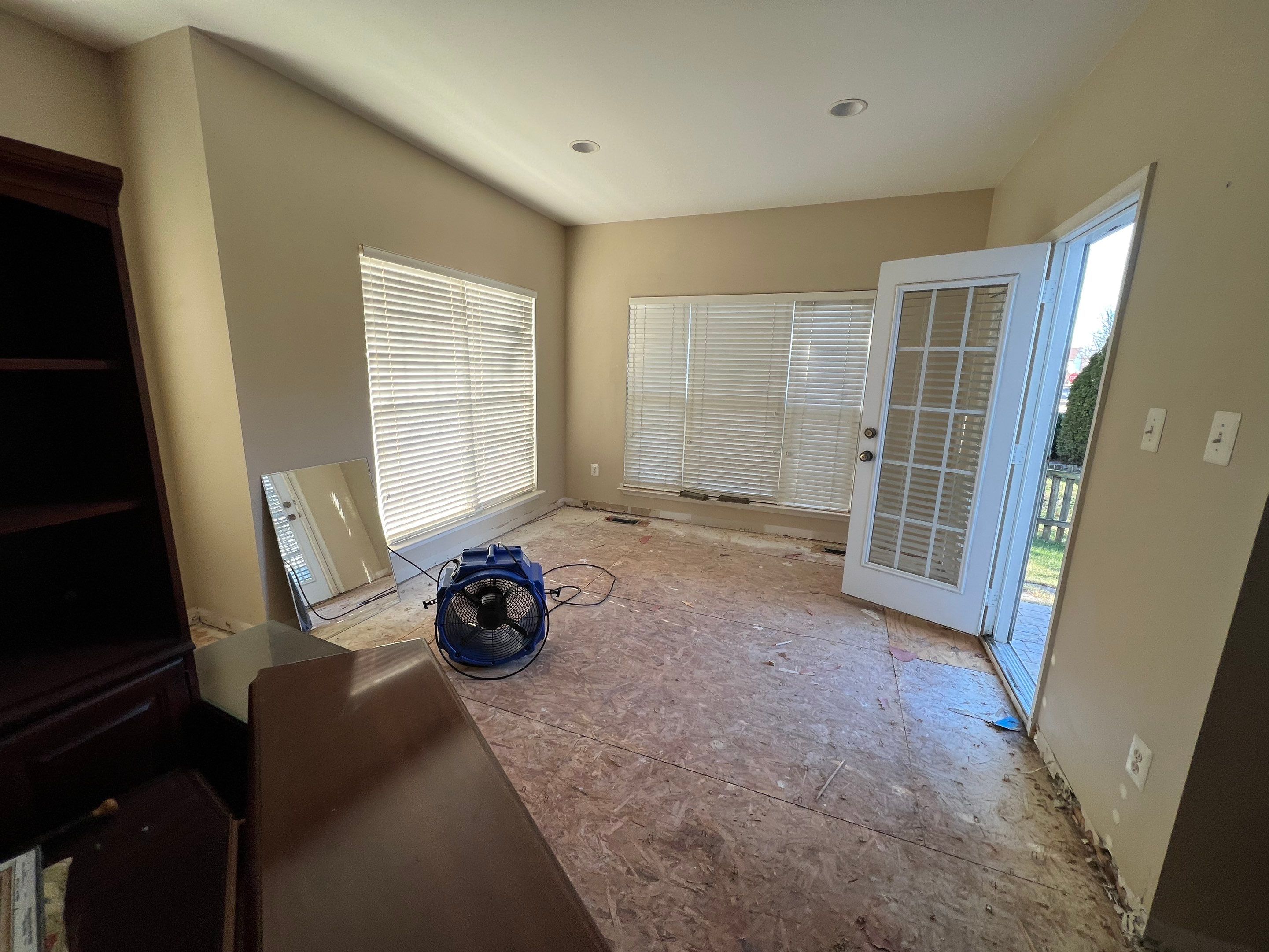 Dehumidification equipment positioned during mid-stage drying of water-damaged interior space.
