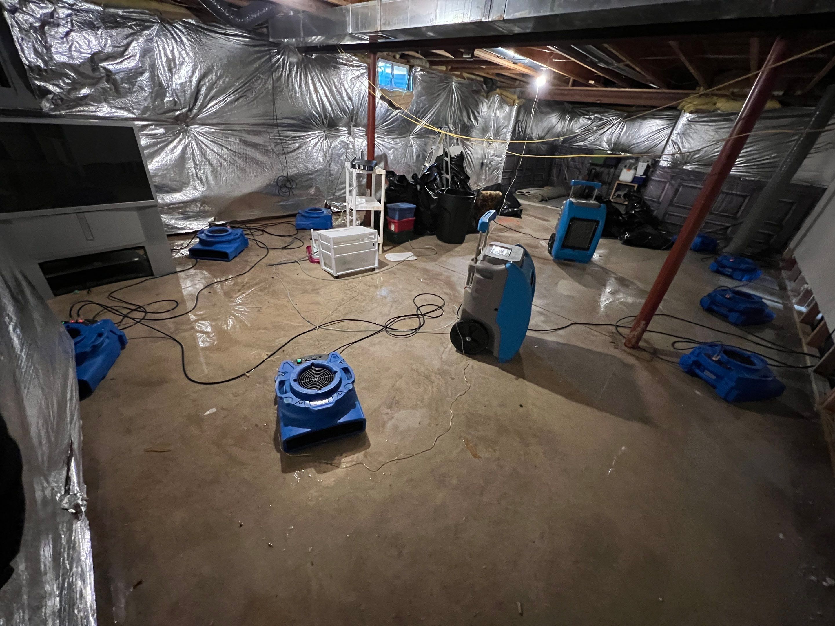 Structural drying in progress with air movers and moisture monitoring equipment deployed.
