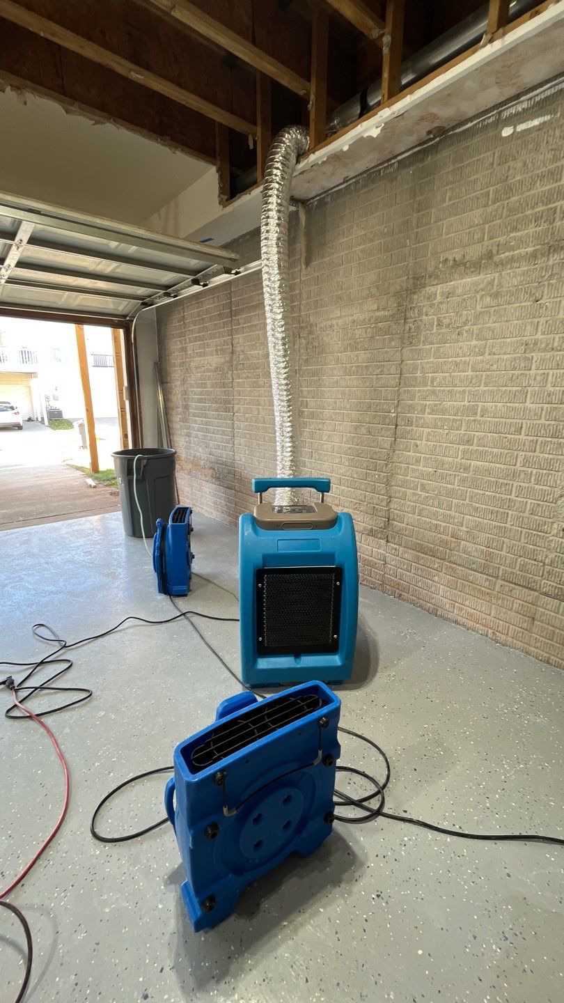 Industrial dehumidifiers and air movers positioned for structural drying phase of water damage restoration process.