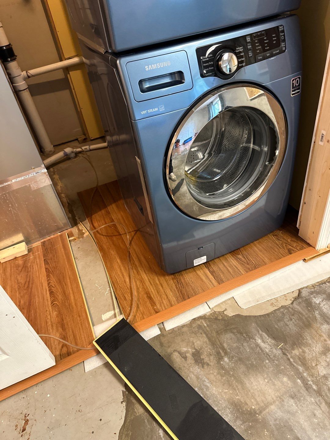 Water-damaged carpet and flooring in Sterling home with dehumidification equipment staged for structural drying.