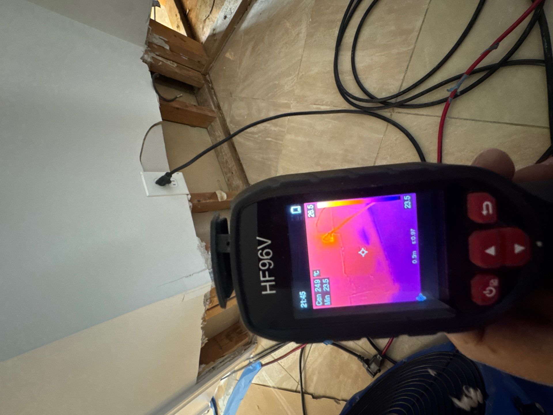 Thermal camera documenting moisture patterns within contained work area during structural drying phase.