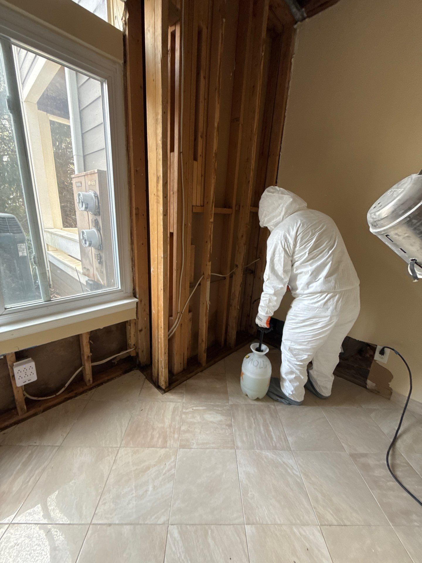 Dehumidification and air movement equipment operating behind containment barrier to dry affected structures.