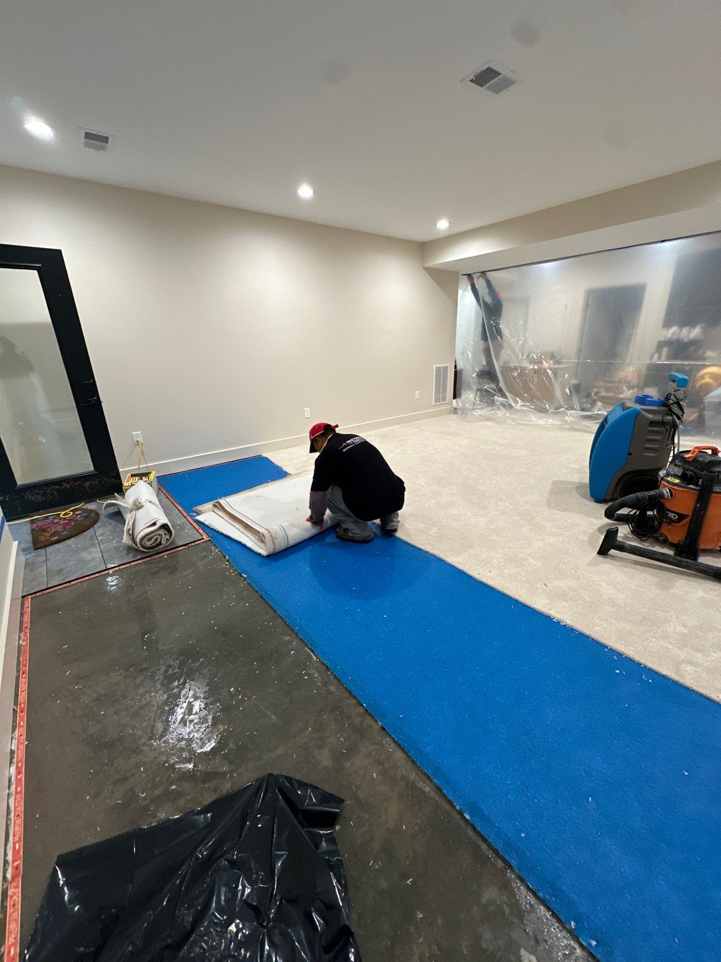 Equipment placement and flooring remediation in progress during water damage restoration drying phase.