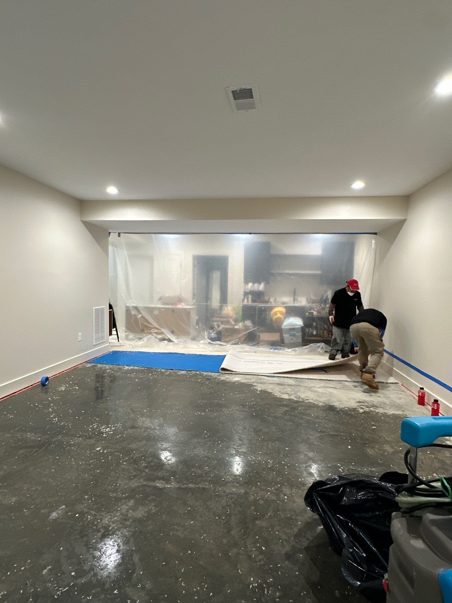 Water-damaged carpet and flooring in Alexandria home with dehumidification equipment positioned for structural drying.