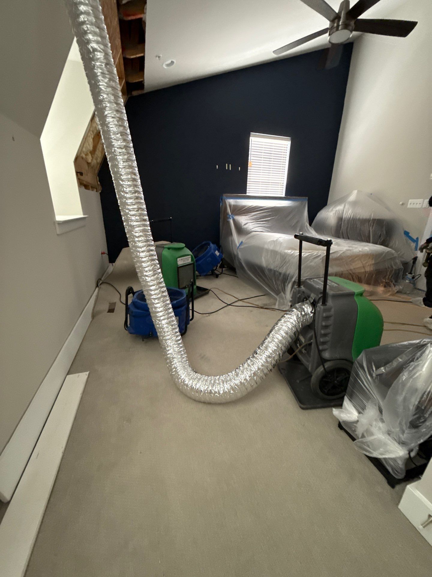 Mid-stage drying phase showing dehumidifier placement and structural assessment for mold remediation work.