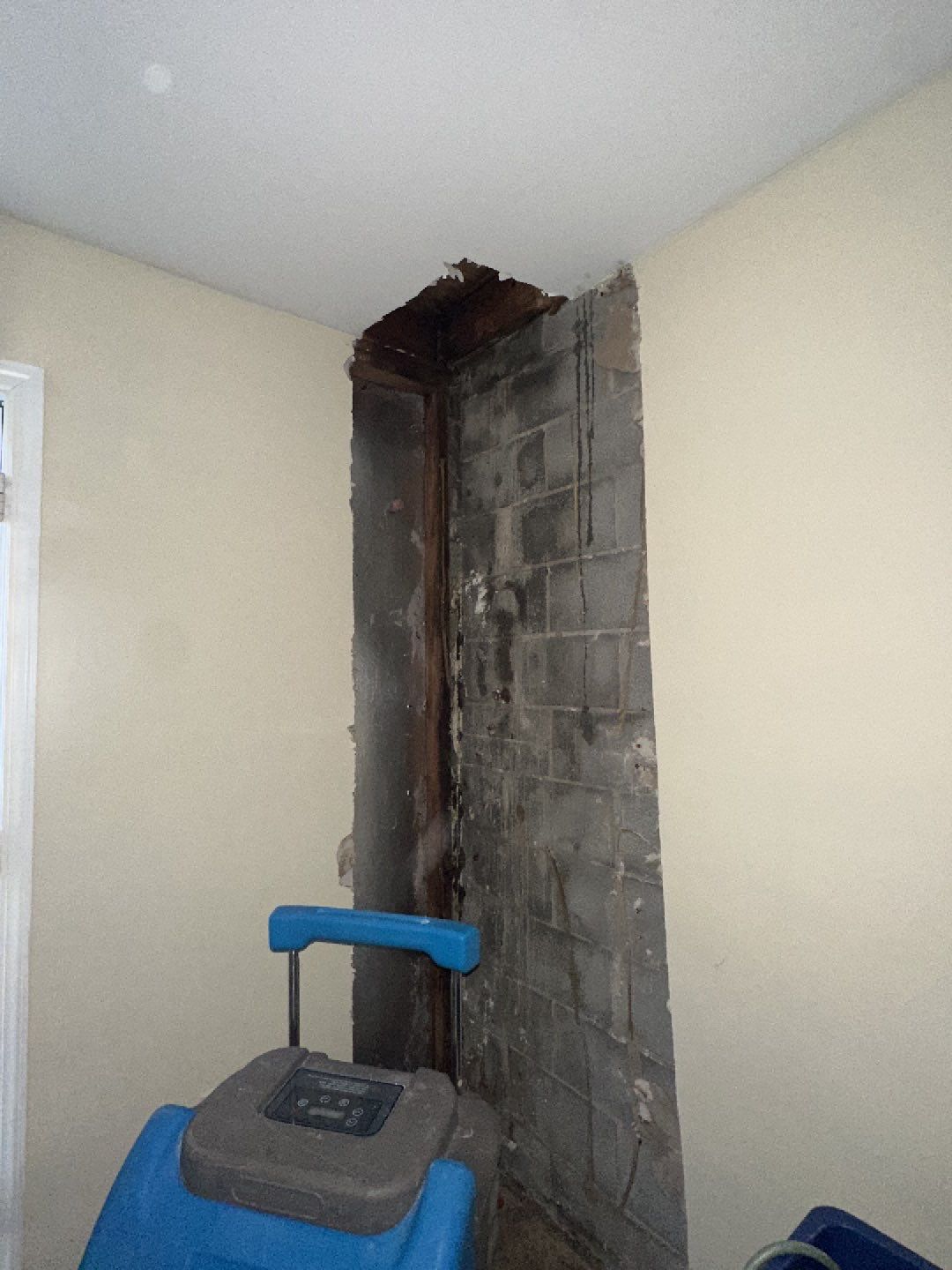 Water-damaged ceiling with visible staining and dehumidification equipment positioned for structural drying in Fredericksburg.