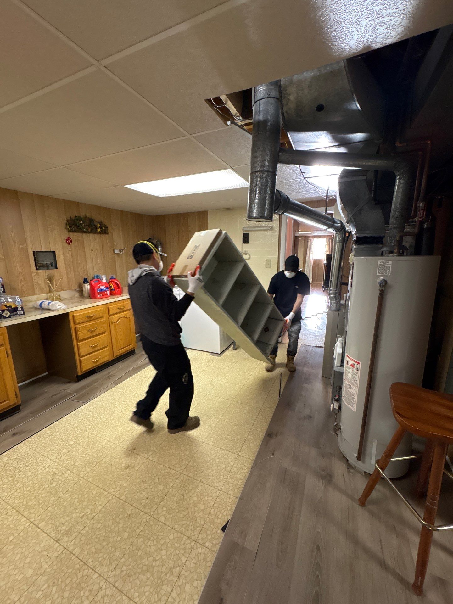 Standing water extraction underway in McLean water damage restoration, wet flooring and structural materials visible.