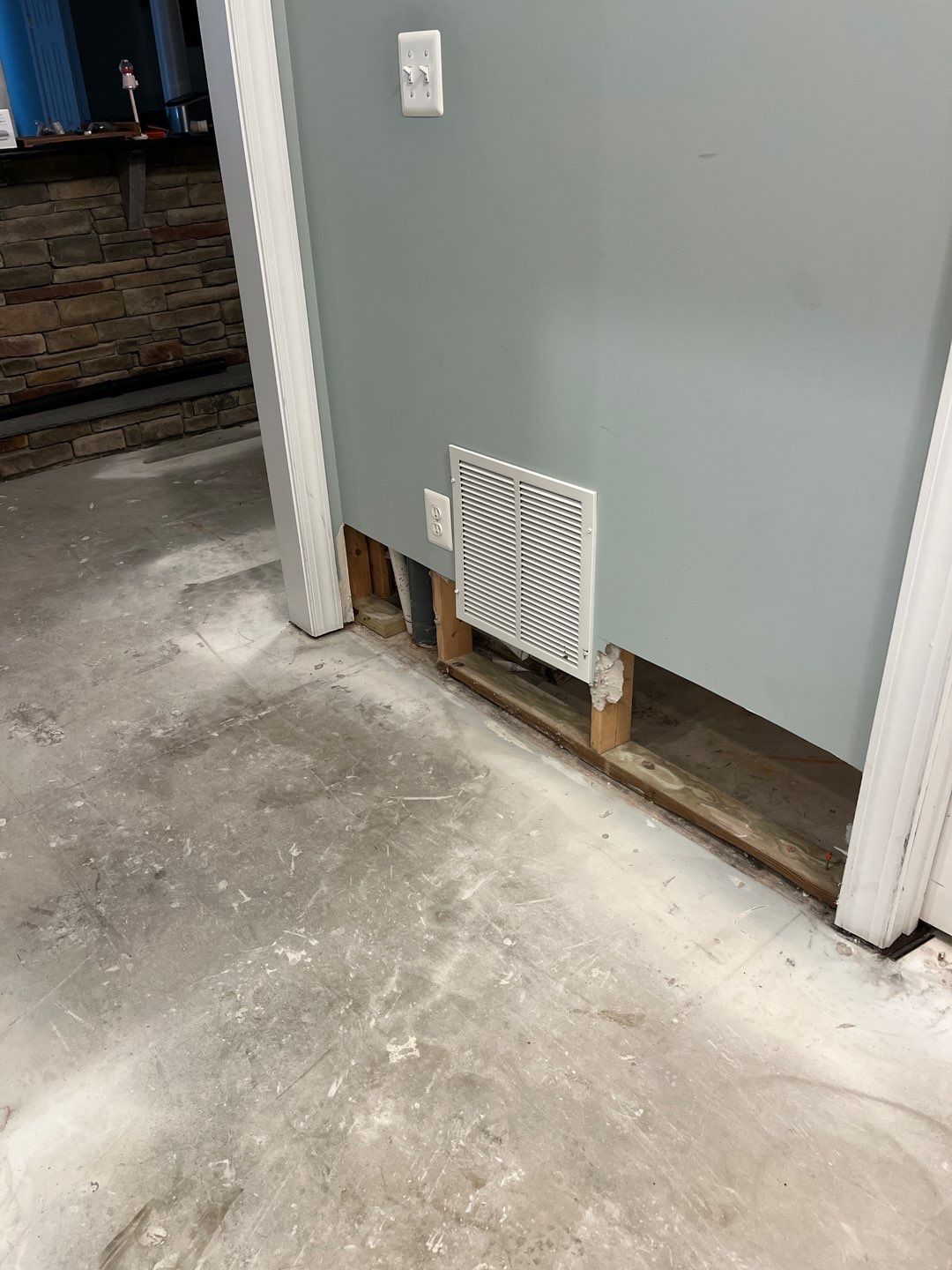 Wet basement surfaces being cleaned and prepared for drying phase of water damage work.