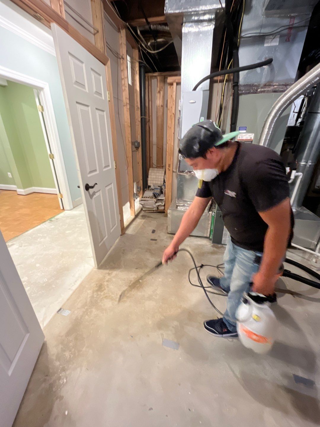 Water extraction equipment removing contaminated water from flooded basement during restoration.