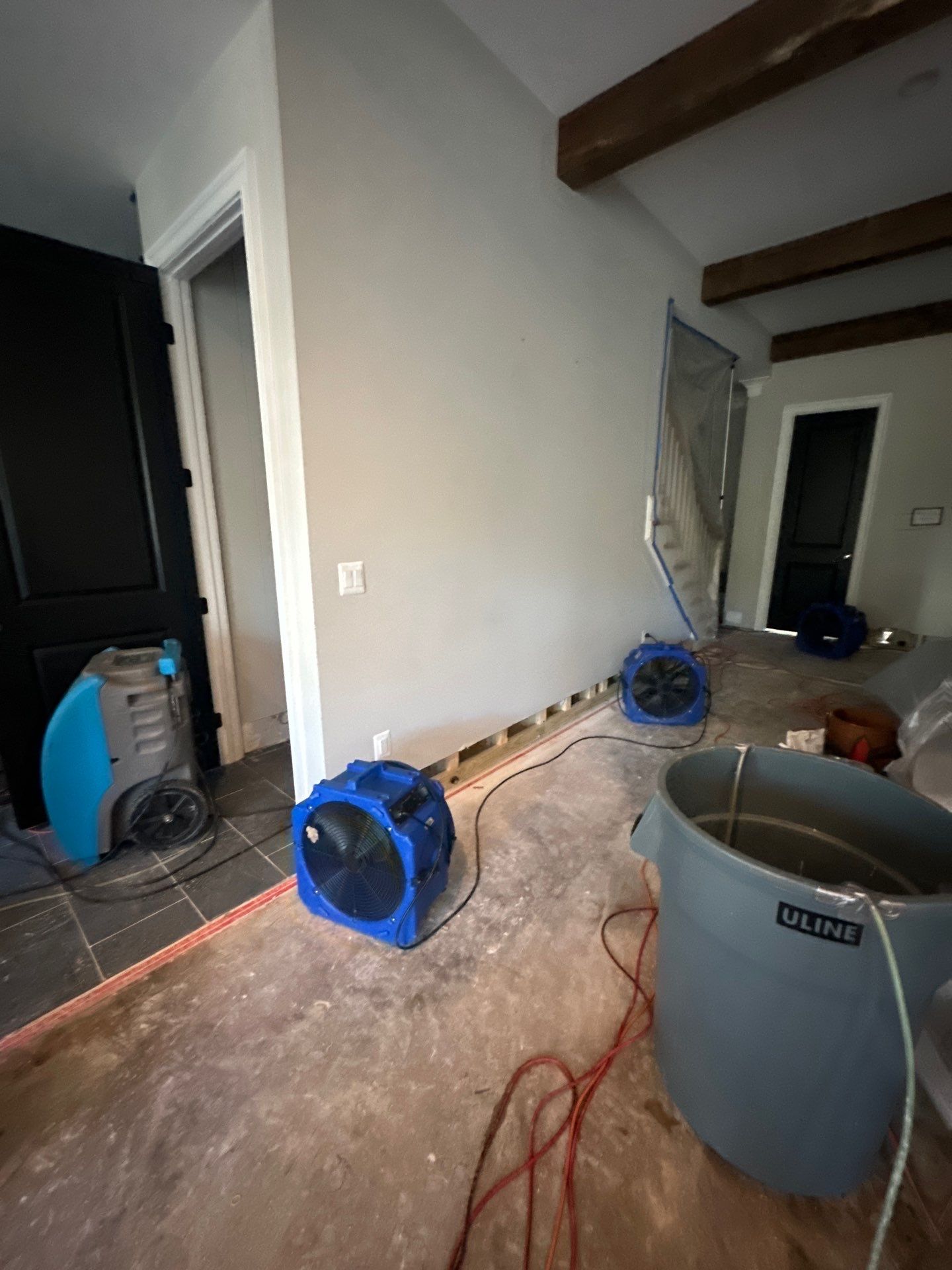 Studs and framing exposed after saturated wall removal in Arlington water damage job.