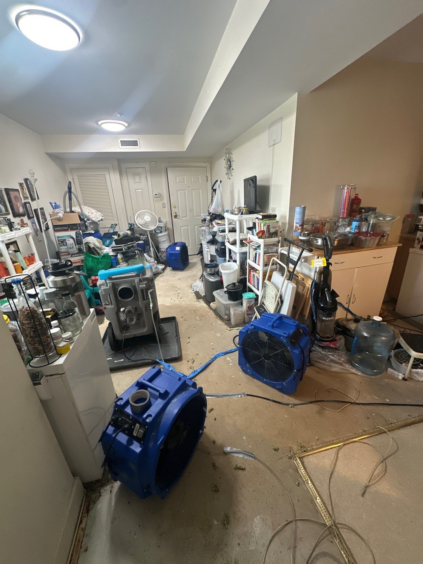 Drying phase continuing with air movers and dehumidifiers positioned throughout affected space.