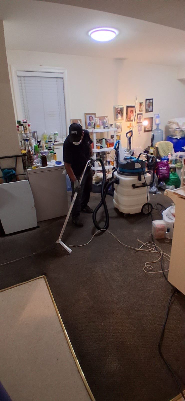 Standing water extraction underway in Alexandria water damage restoration, wet flooring visible.