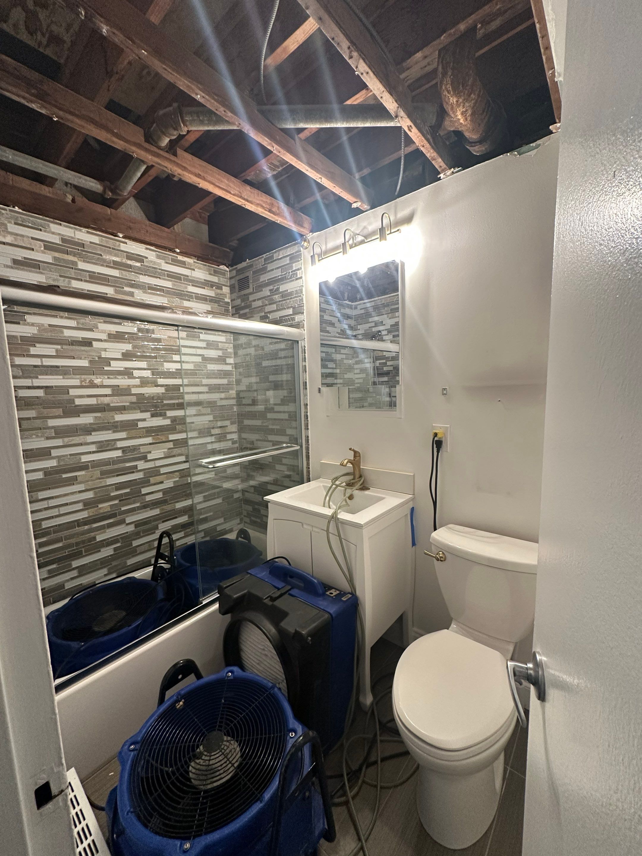 Containment barrier and wet ceiling material removal during water damage restoration work.
