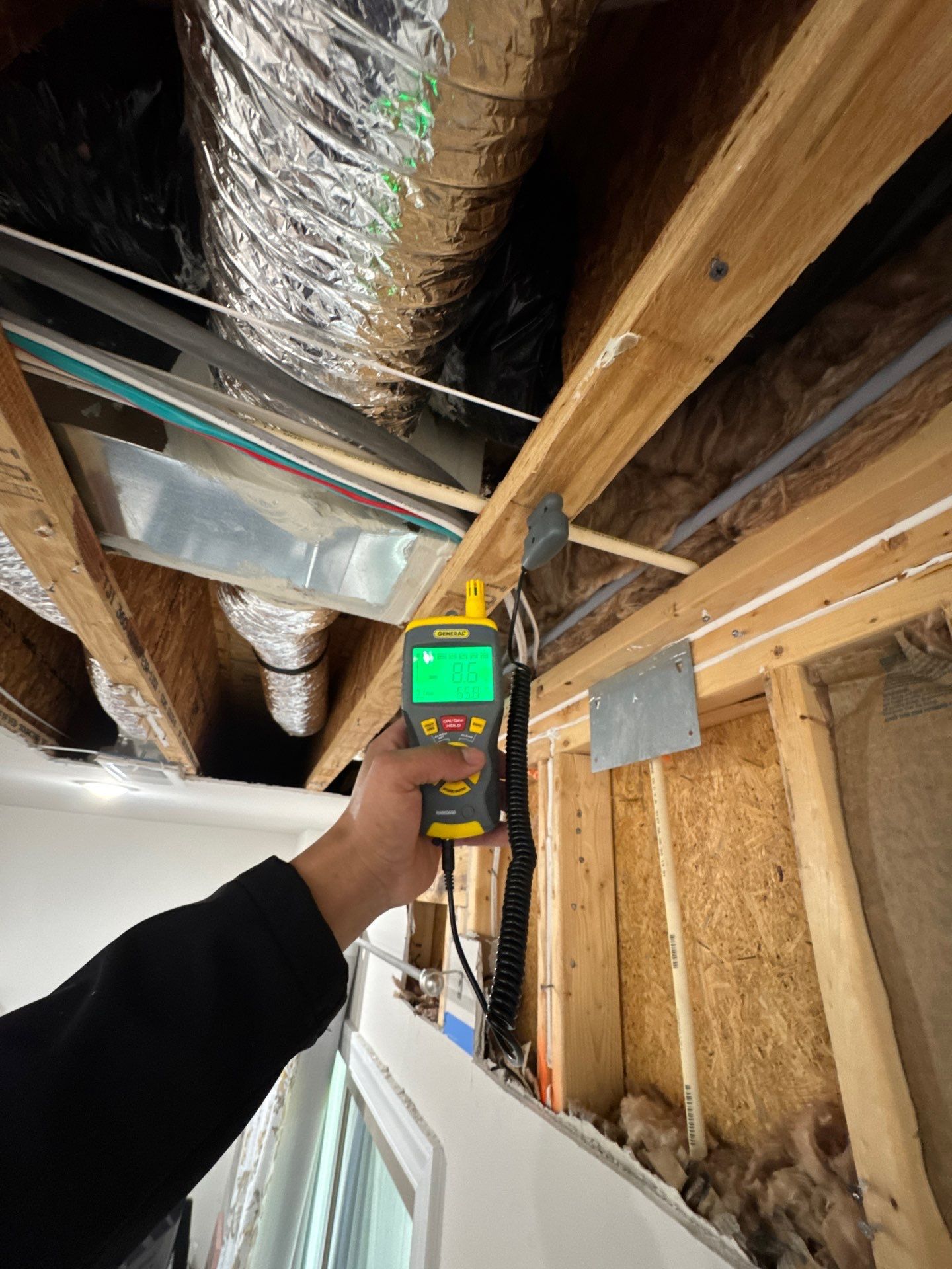 Ceiling repair in progress with structural materials exposed during water damage restoration.