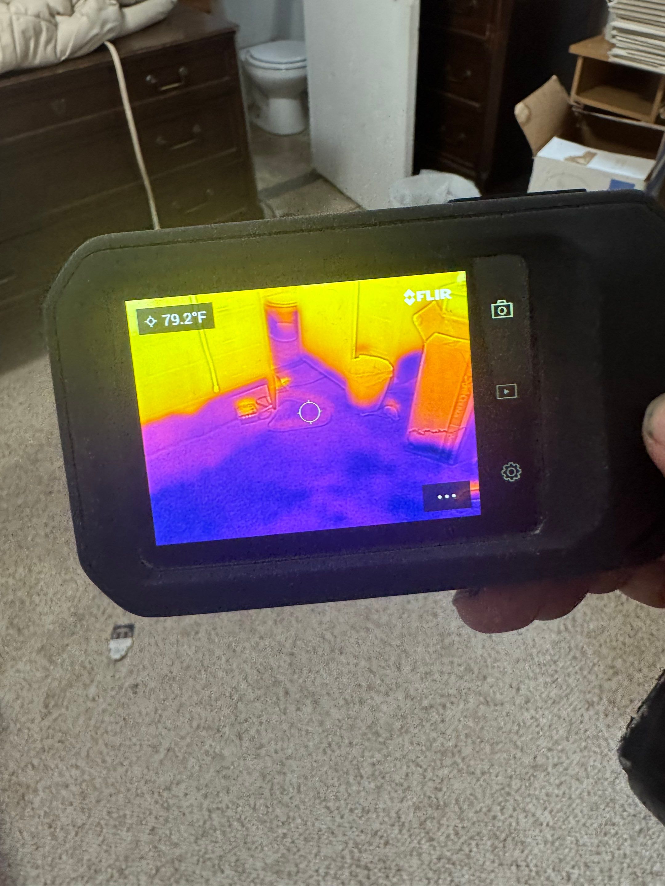 Thermal imaging camera capturing moisture patterns in Arlington ceiling during water damage assessment.