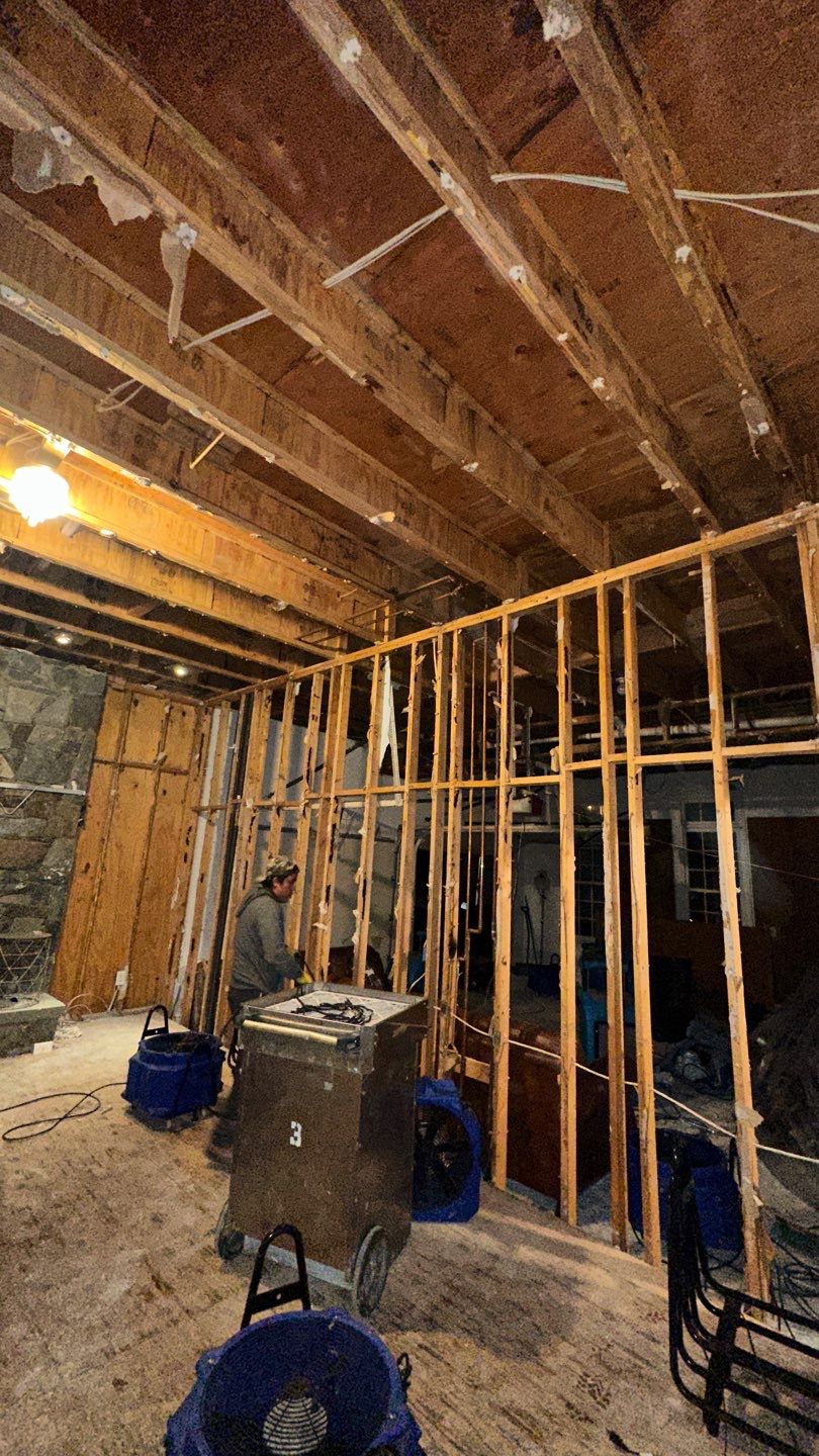 Structural drying in progress with dehumidification equipment operating to extract moisture from walls and ceiling.