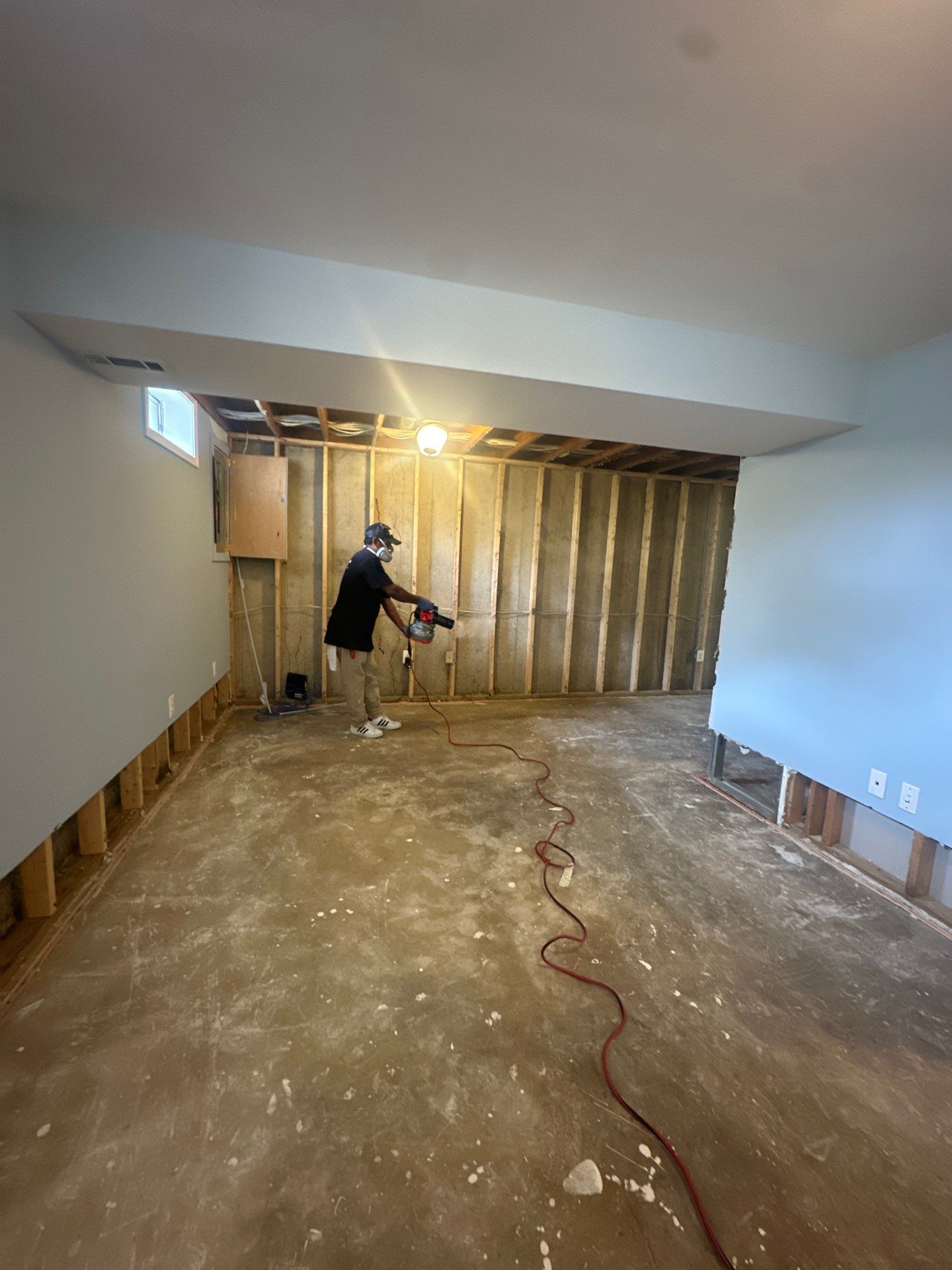 Dehumidifier and air movers deployed across affected room during water damage restoration drying phase.