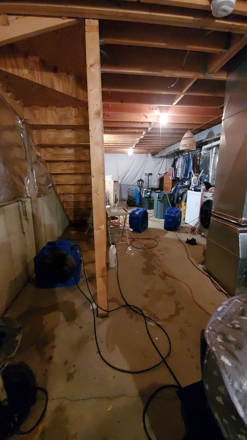 Dehumidification setup with ducting and containment barriers in place for controlled drying in Leesburg home.