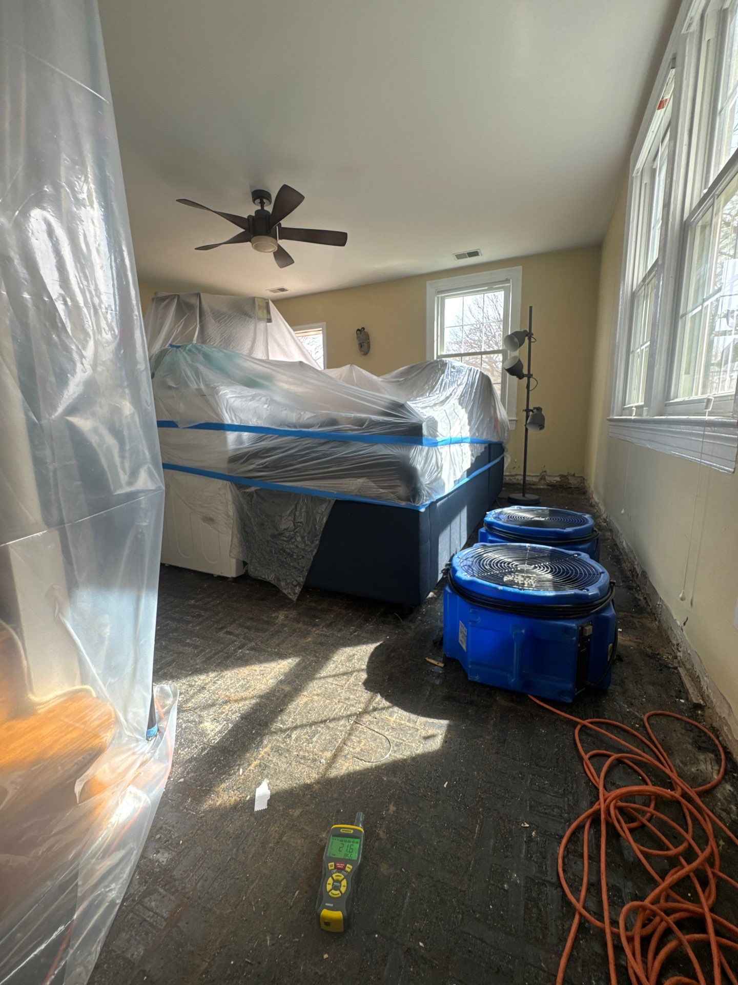 Containment barrier erected around water-damaged area in Arlington home during initial assessment and standing-water extraction.