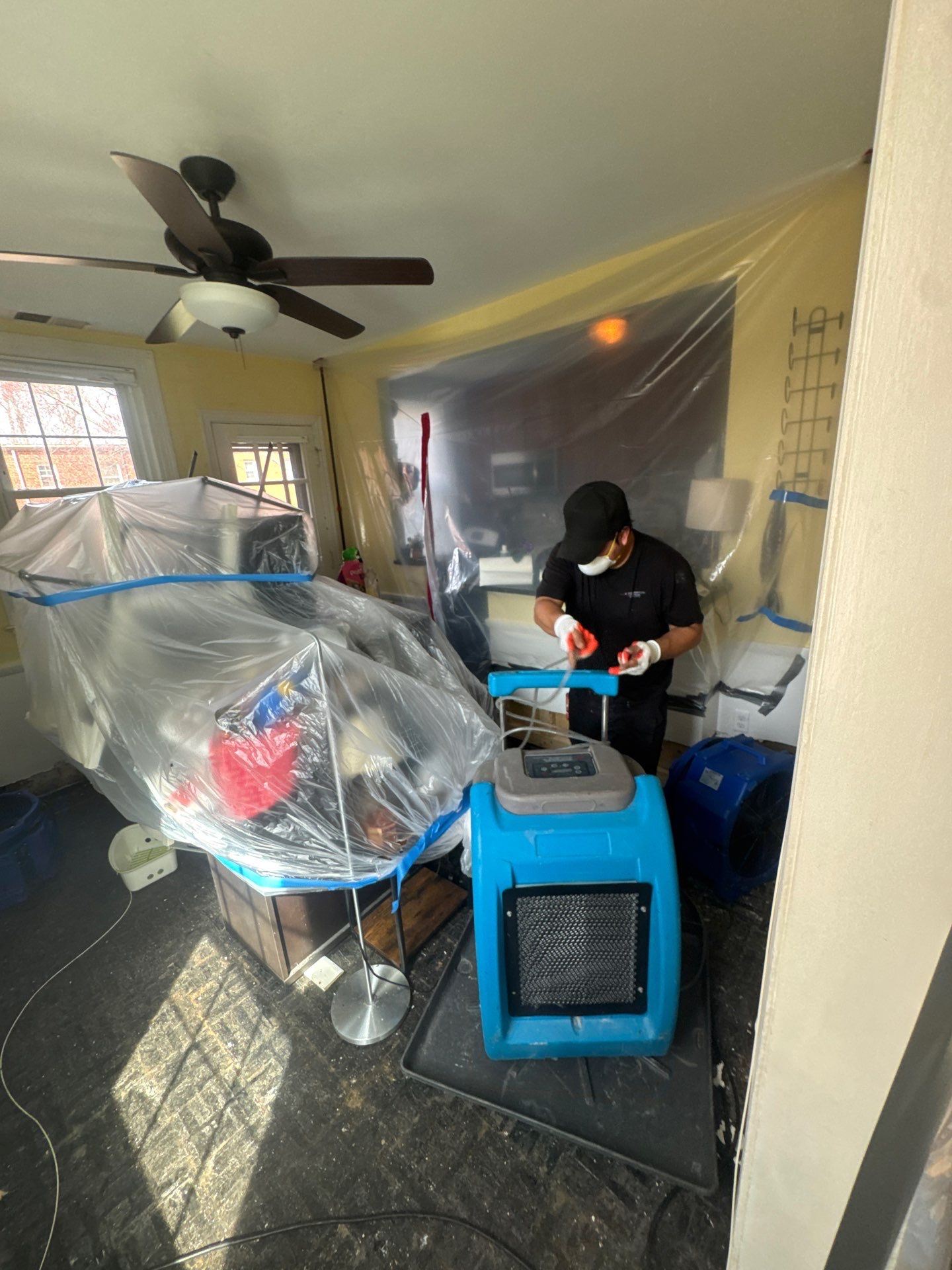 Mid-stage drying phase showing moisture removal equipment and barrier maintaining isolation during Arlington water restoration work.