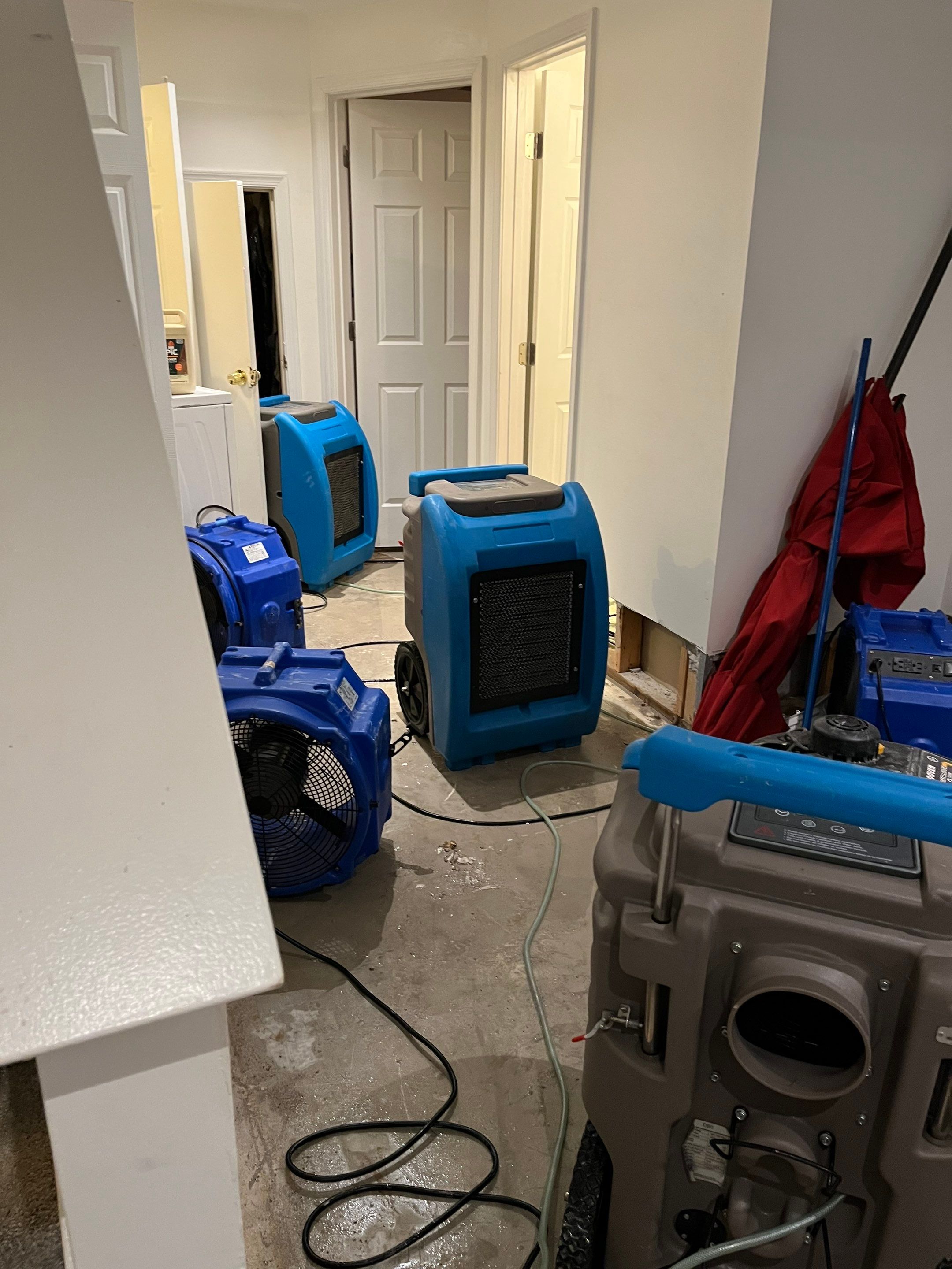 Standing water extraction underway in Dumfries water damage restoration, portable extractors removing pooled water from affected floor.