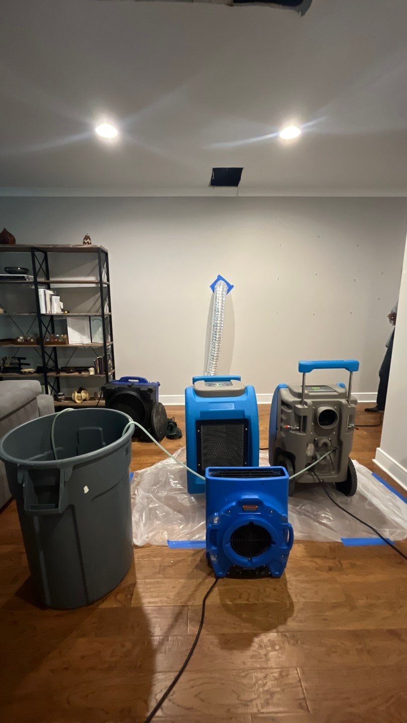 Standing water extraction underway in Franconia water damage restoration, wet flooring and structural materials visible.
