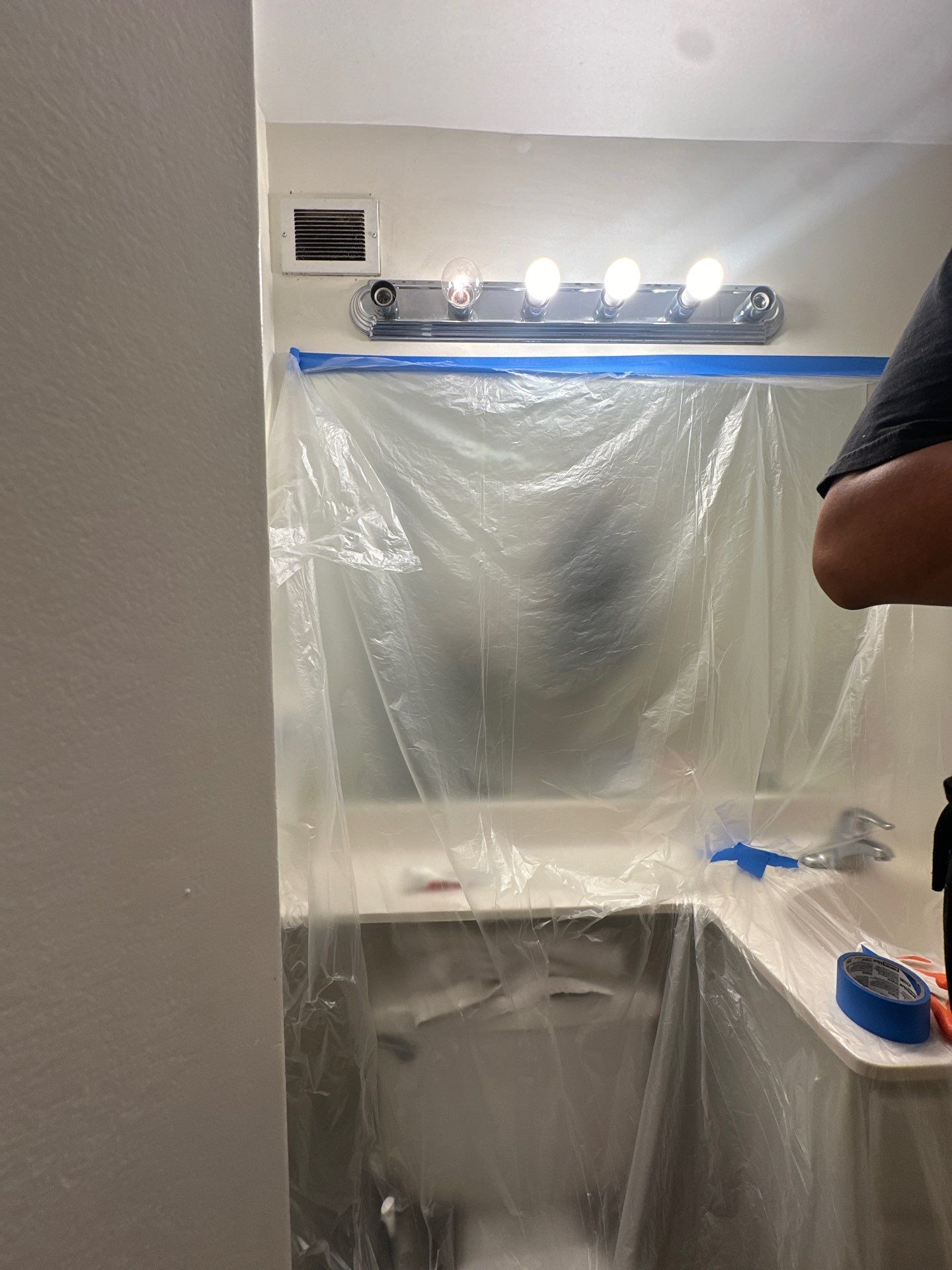 Containment barrier erected around water-damaged wall and ceiling section in Arlington home during initial assessment phase.
