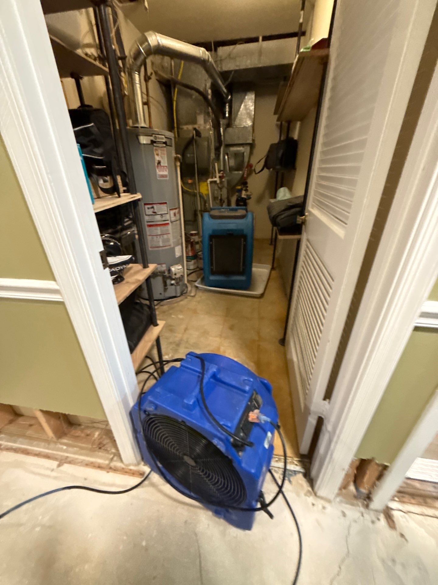 Structural drying equipment positioned to remove moisture from walls and framing after water extraction.