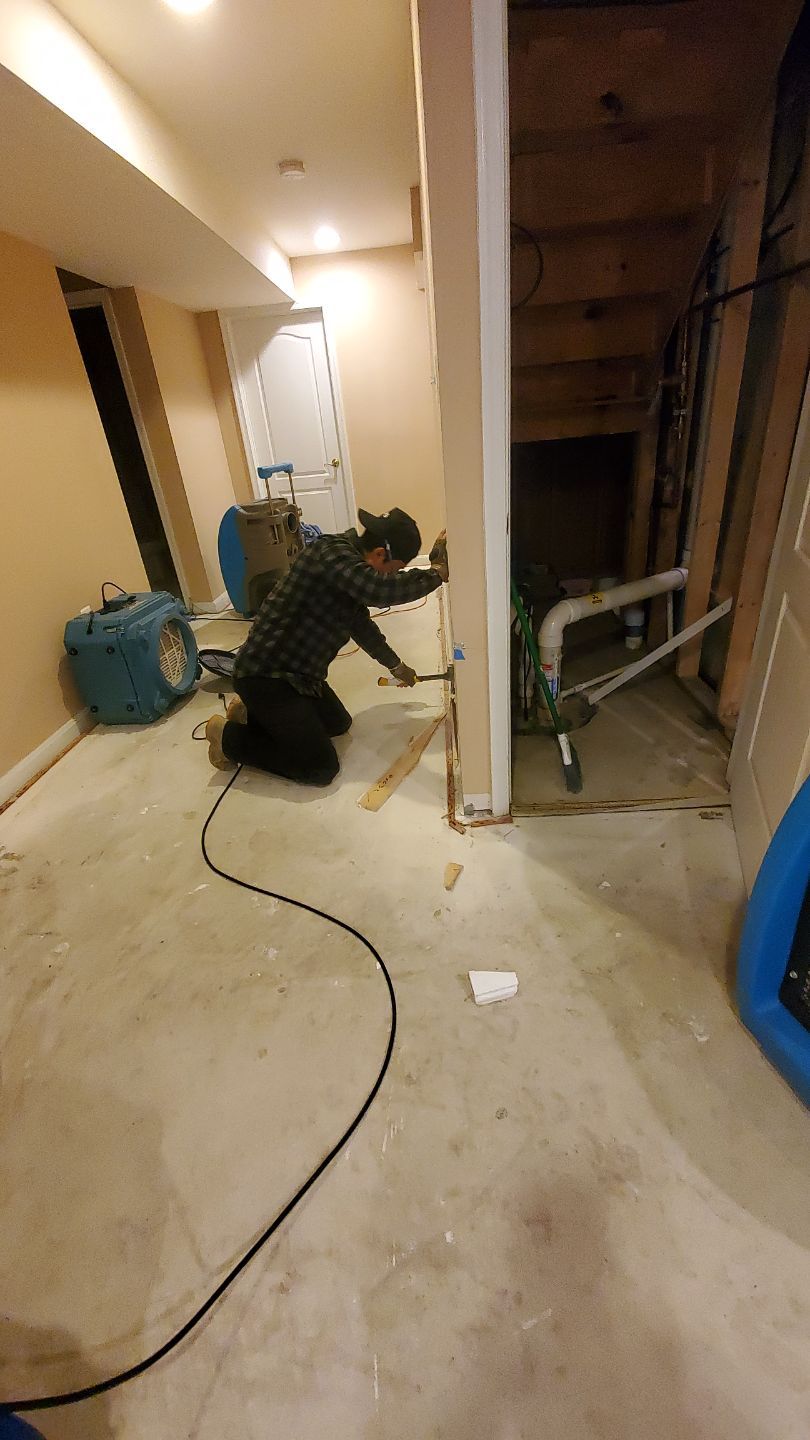 Mid-stage water restoration showing continued dehumidification and air circulation setup.