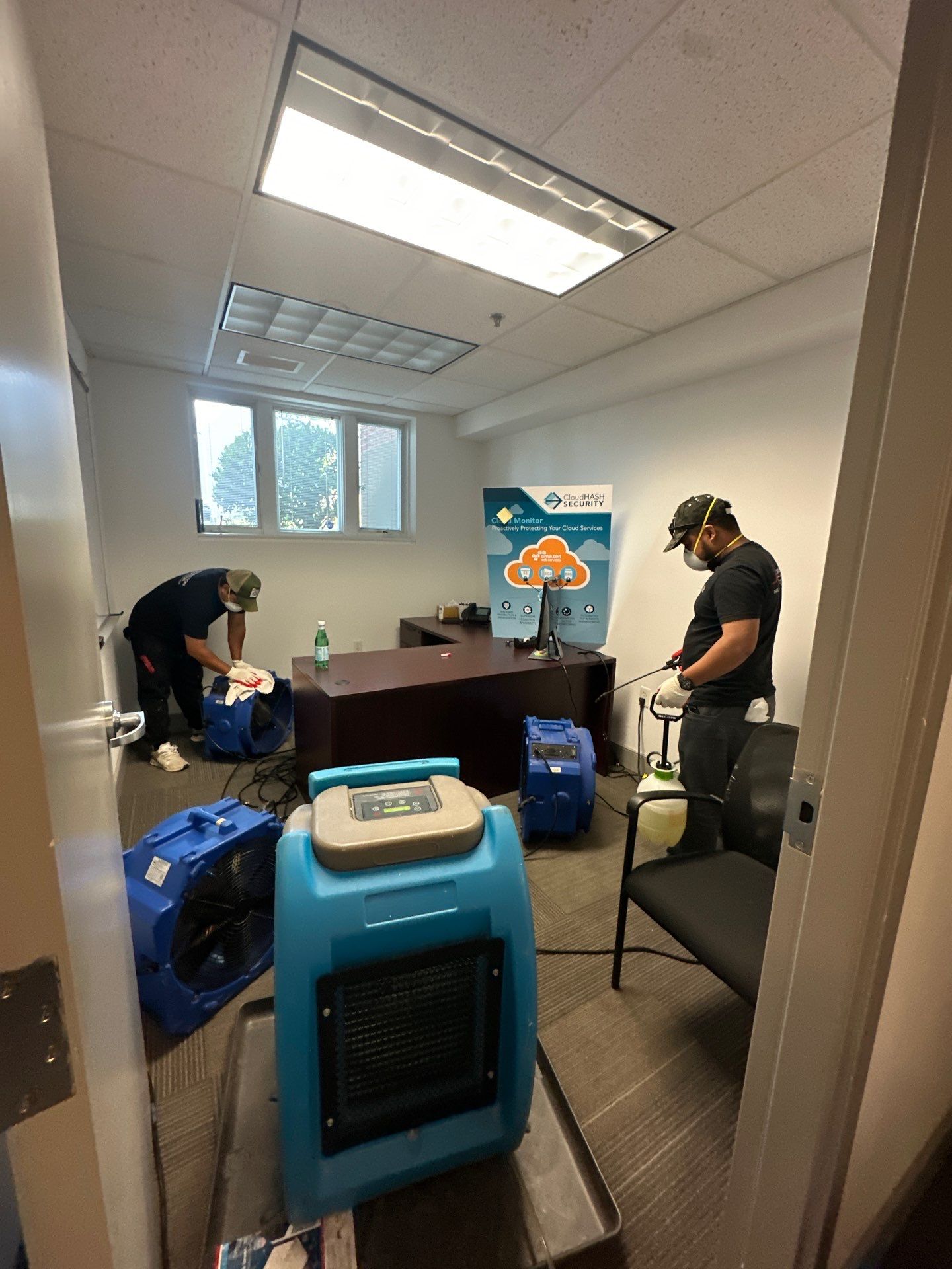 Dehumidification units positioned to dry affected areas after water extraction and barrier installation.