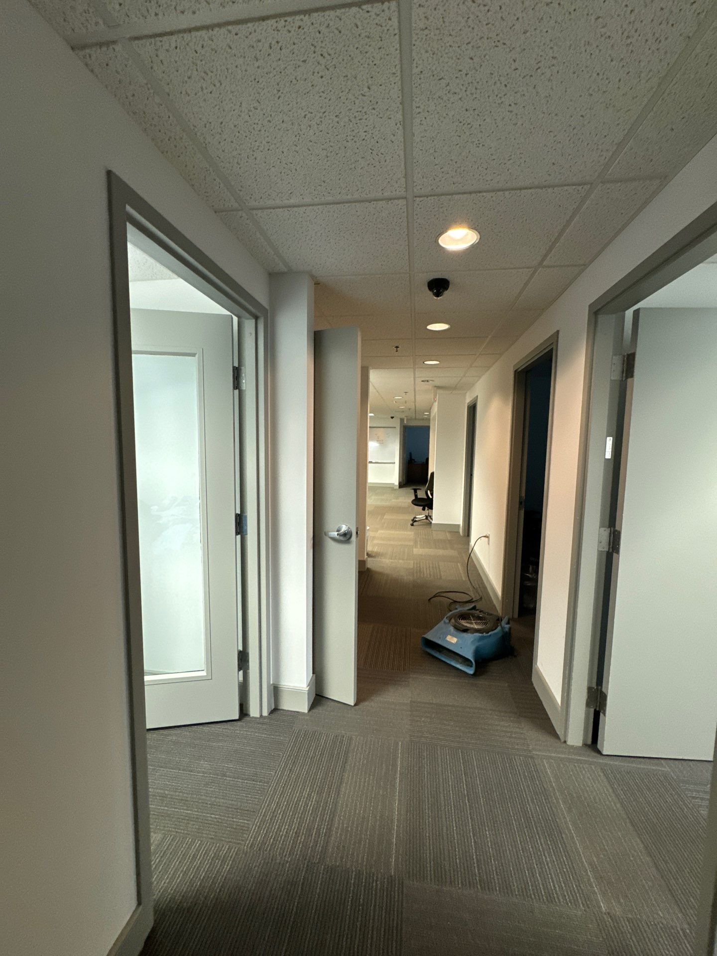 Final stages of water damage restoration showing cleared space and dehumidification equipment in operation.