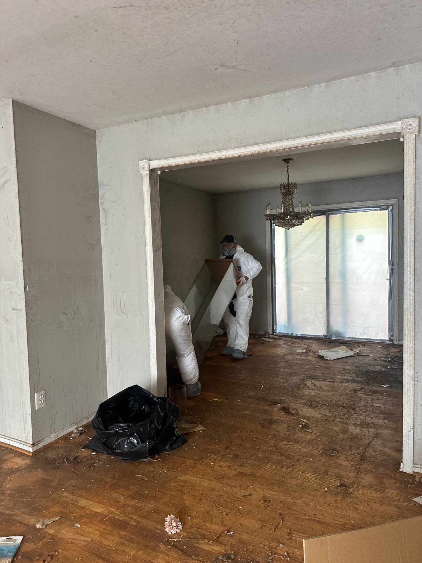 Mid-stage drying process showing exposed framing, removed flooring, and active moisture extraction equipment.