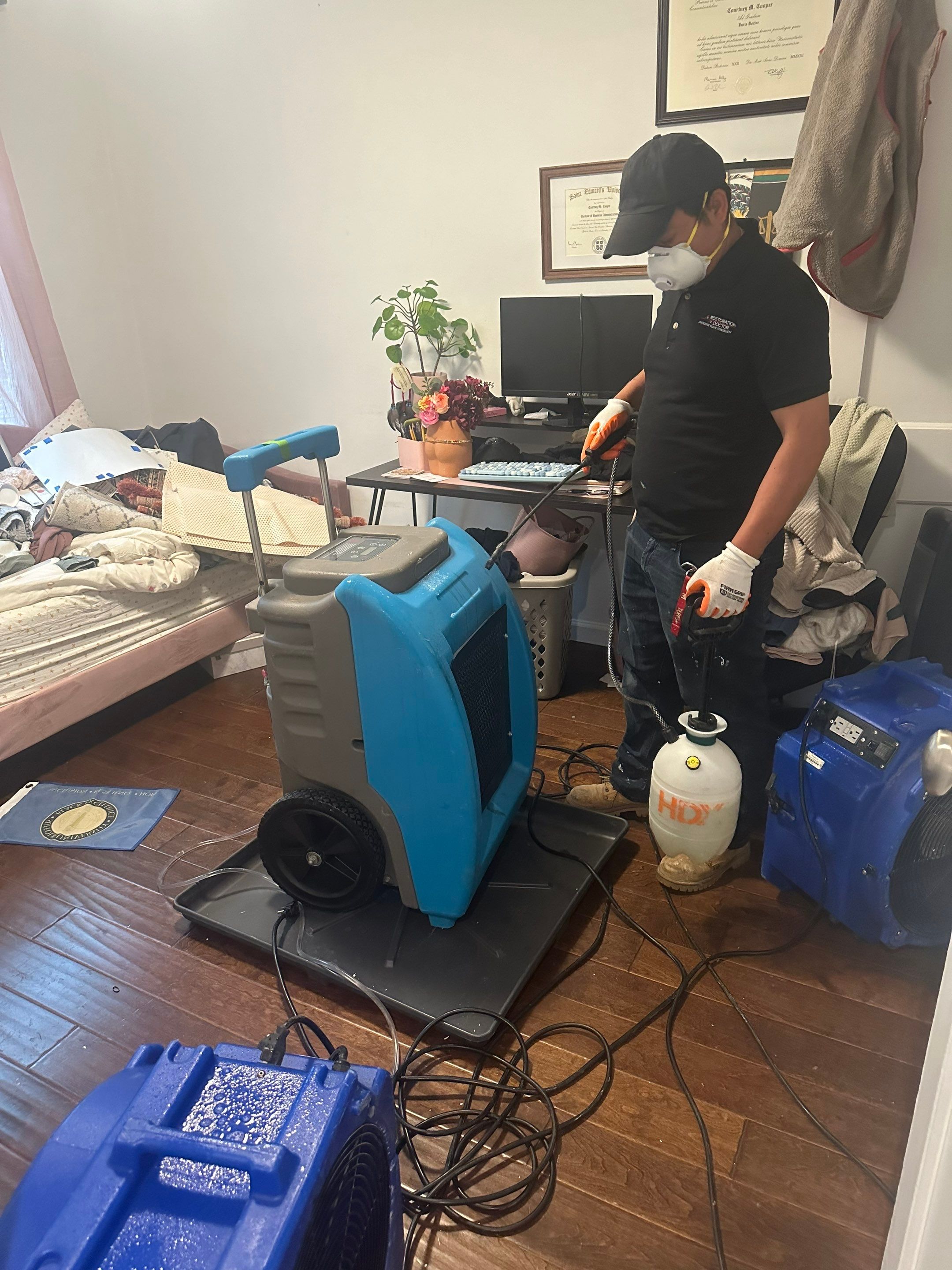 Water-damaged carpet and flooring in Vienna home with dehumidification equipment staged for structural drying.