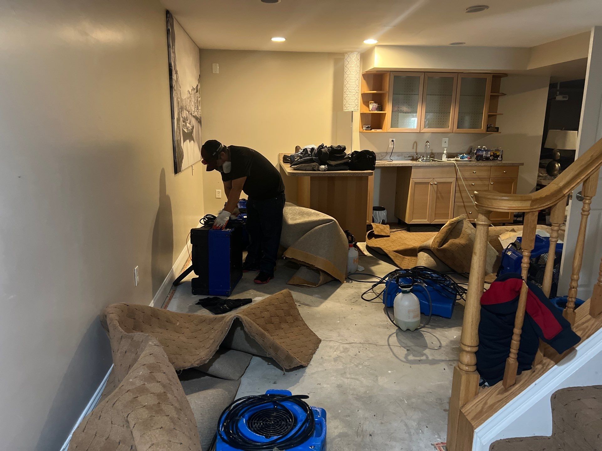 Water-damaged carpet and flooring in Centreville home with dehumidification equipment positioned for structural drying.