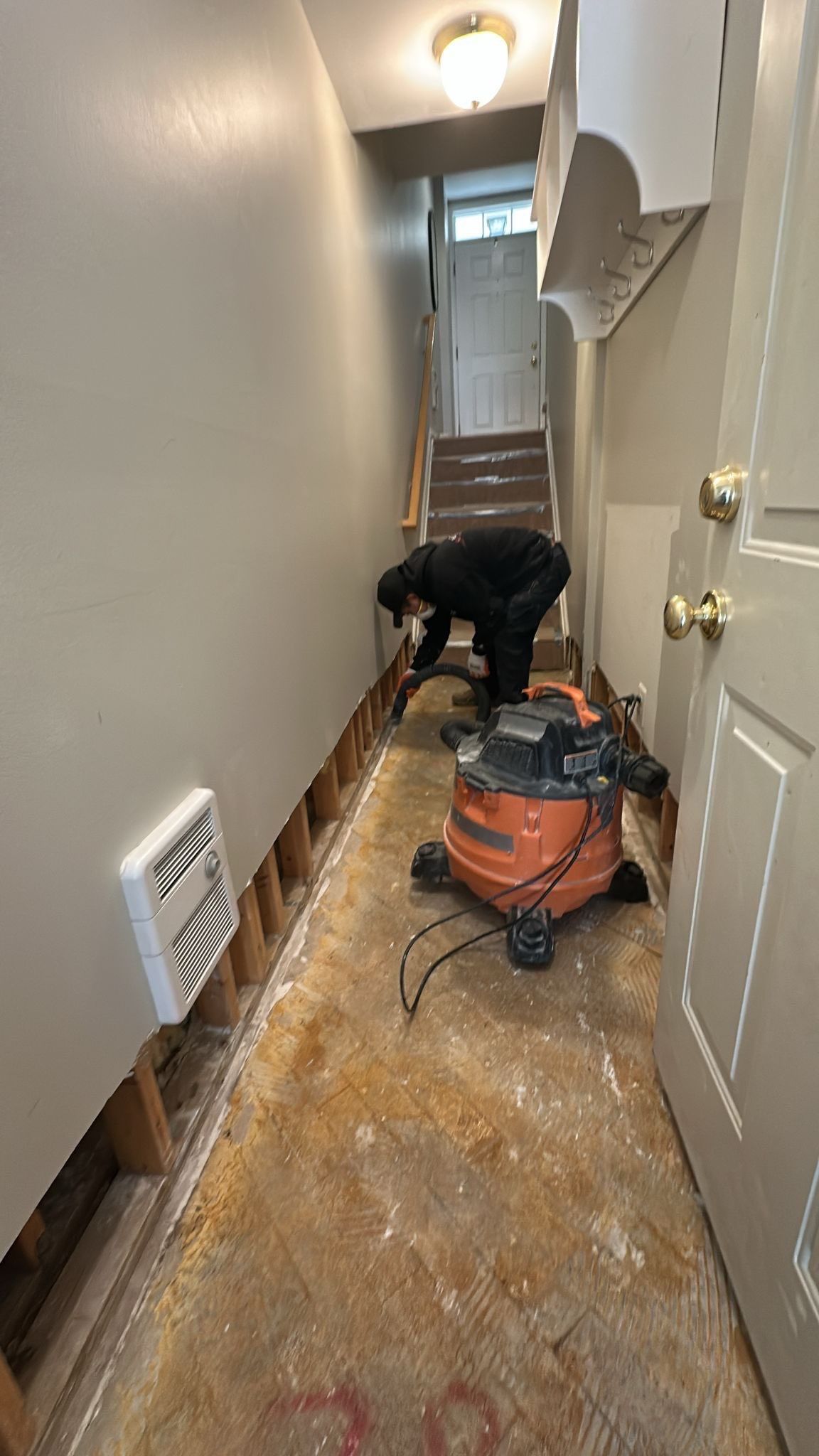 Baseboard removal and preparation for replacement following water damage extraction.