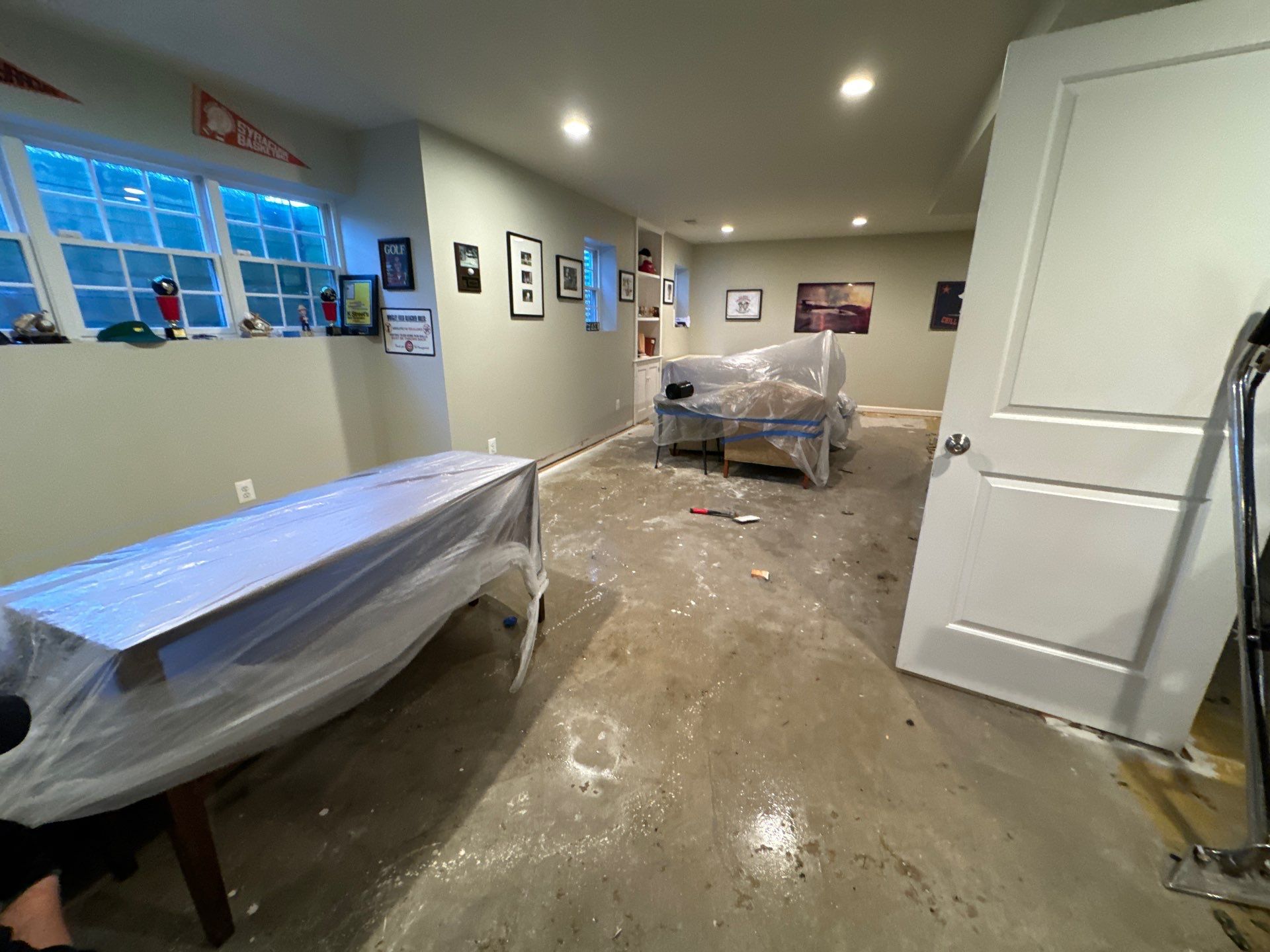 Dehumidifiers and air movers positioned throughout affected room during water damage restoration in Alexandria.